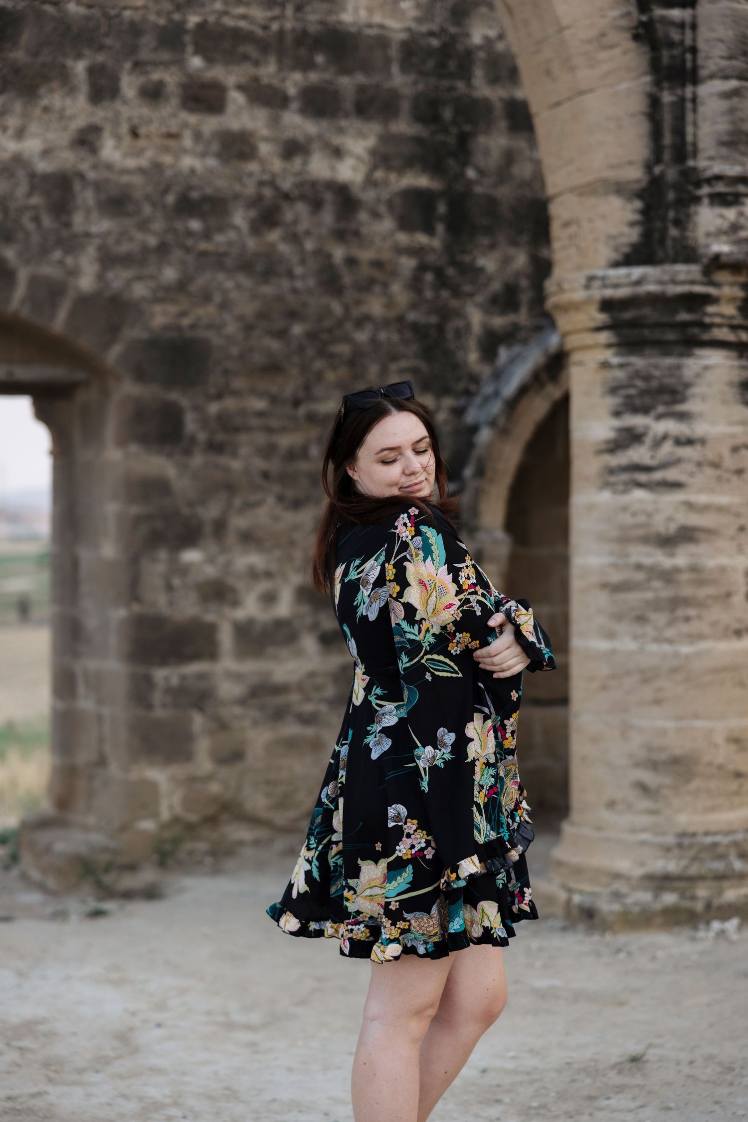 Woman posing beside ancient stone columns during an outdoor portrait session in Cyprus