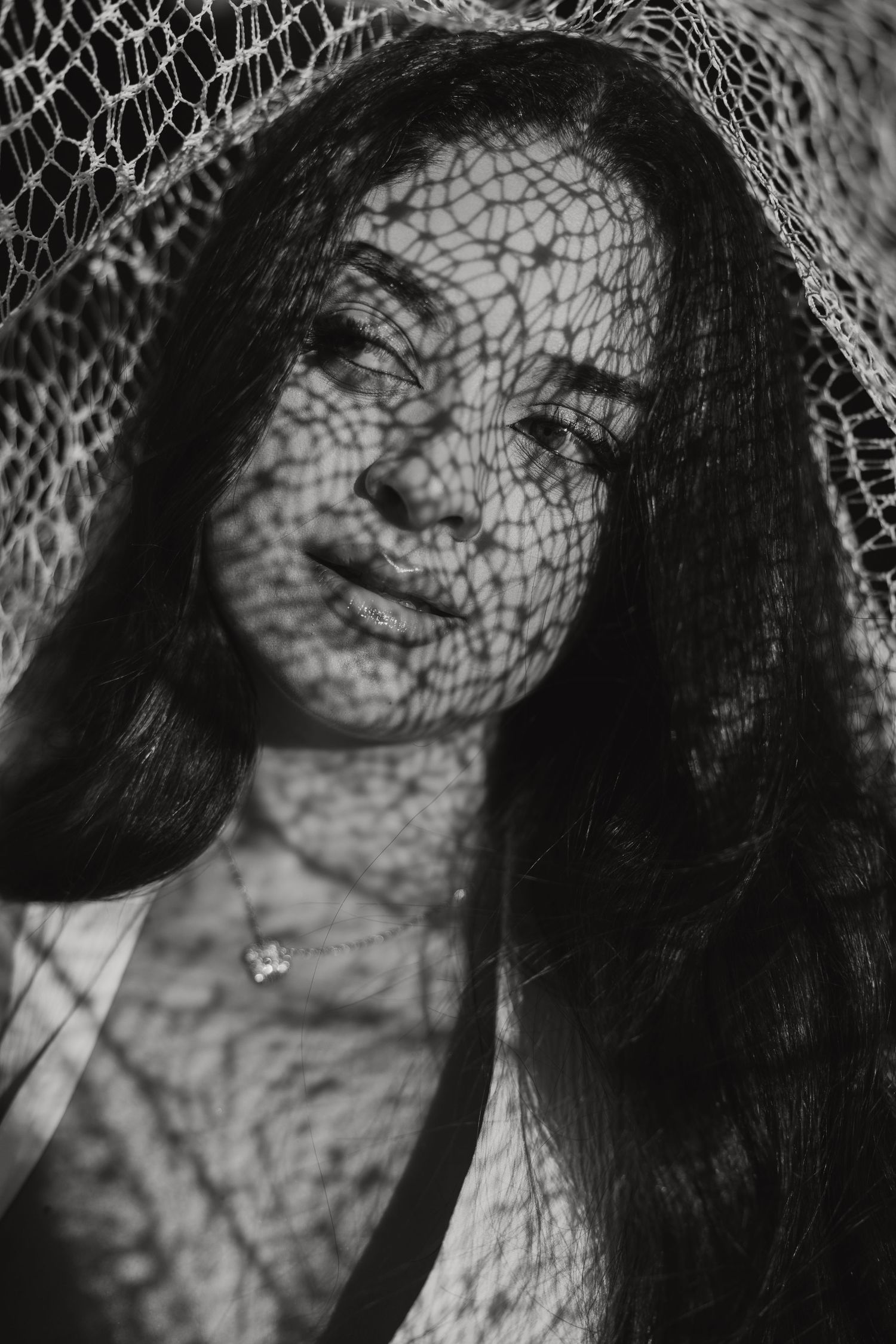 Black and white artistic portrait of a woman with sunlight patterns on her face during a Cyprus photoshoot