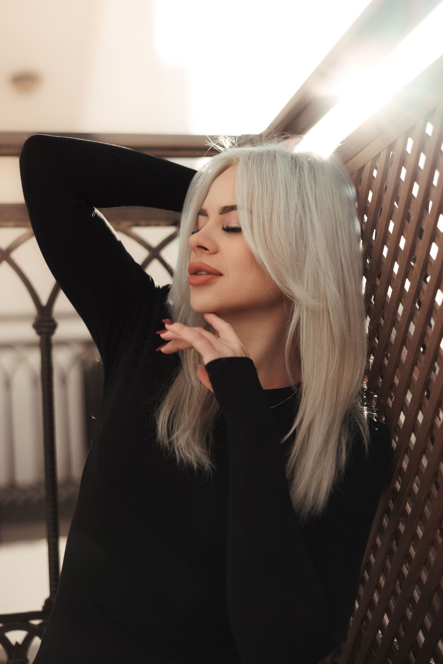 Blonde woman posing indoors with warm lighting during a modern portrait photoshoot in Cyprus