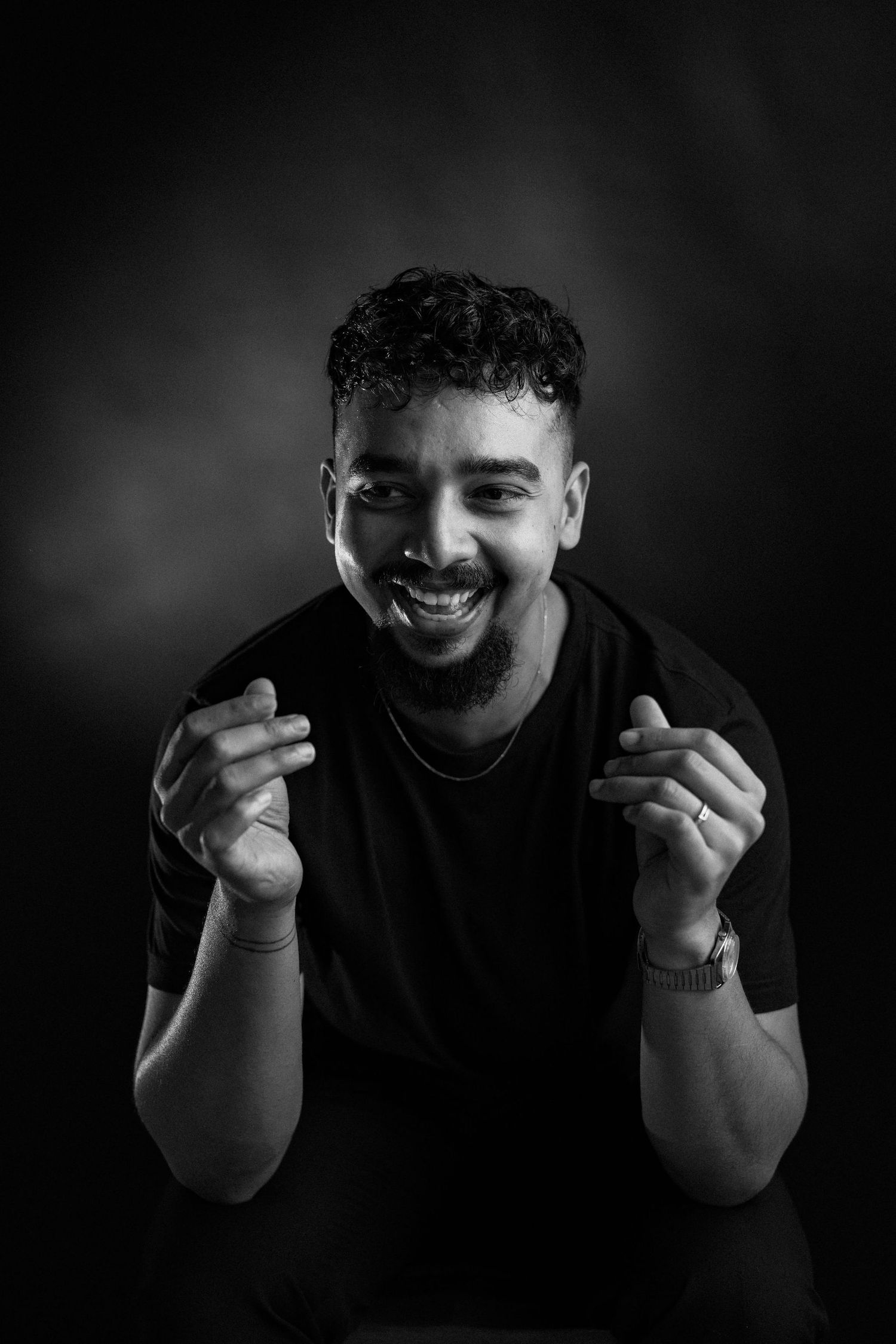 A sequence of moody black and white portraits showing hands raised near the face with expressive gestures in low-key lighting.