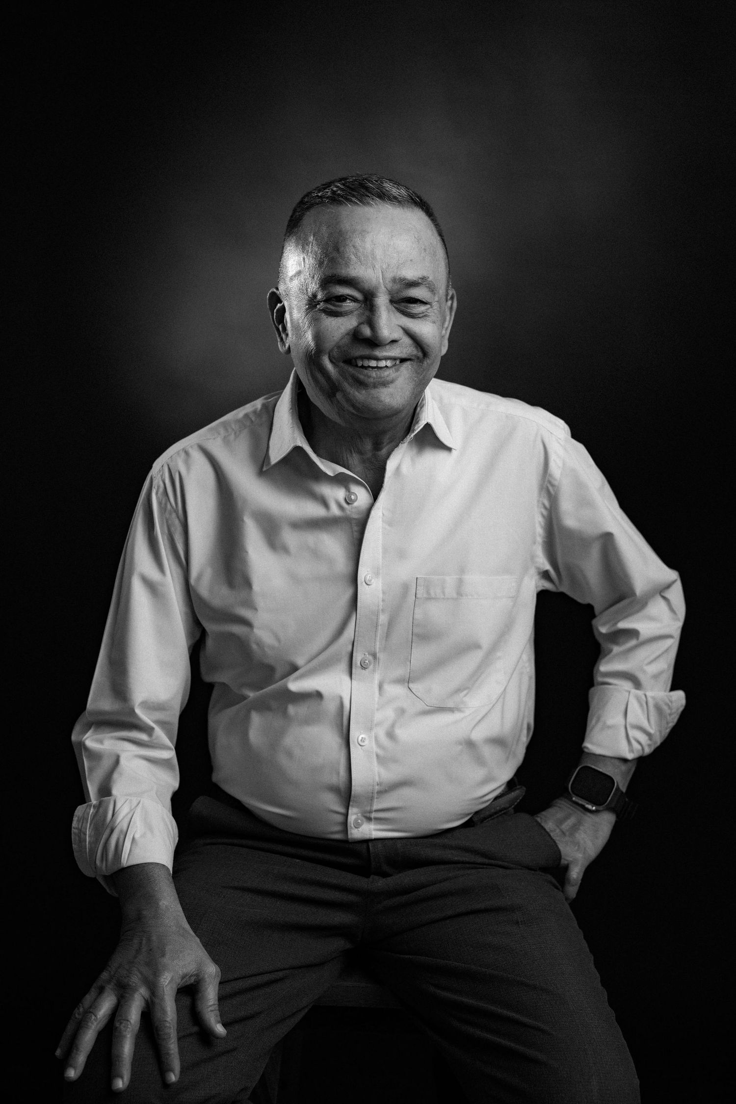 Black and white portrait series showing expressive moments of an elderly person in a white shirt against dark backdrop.