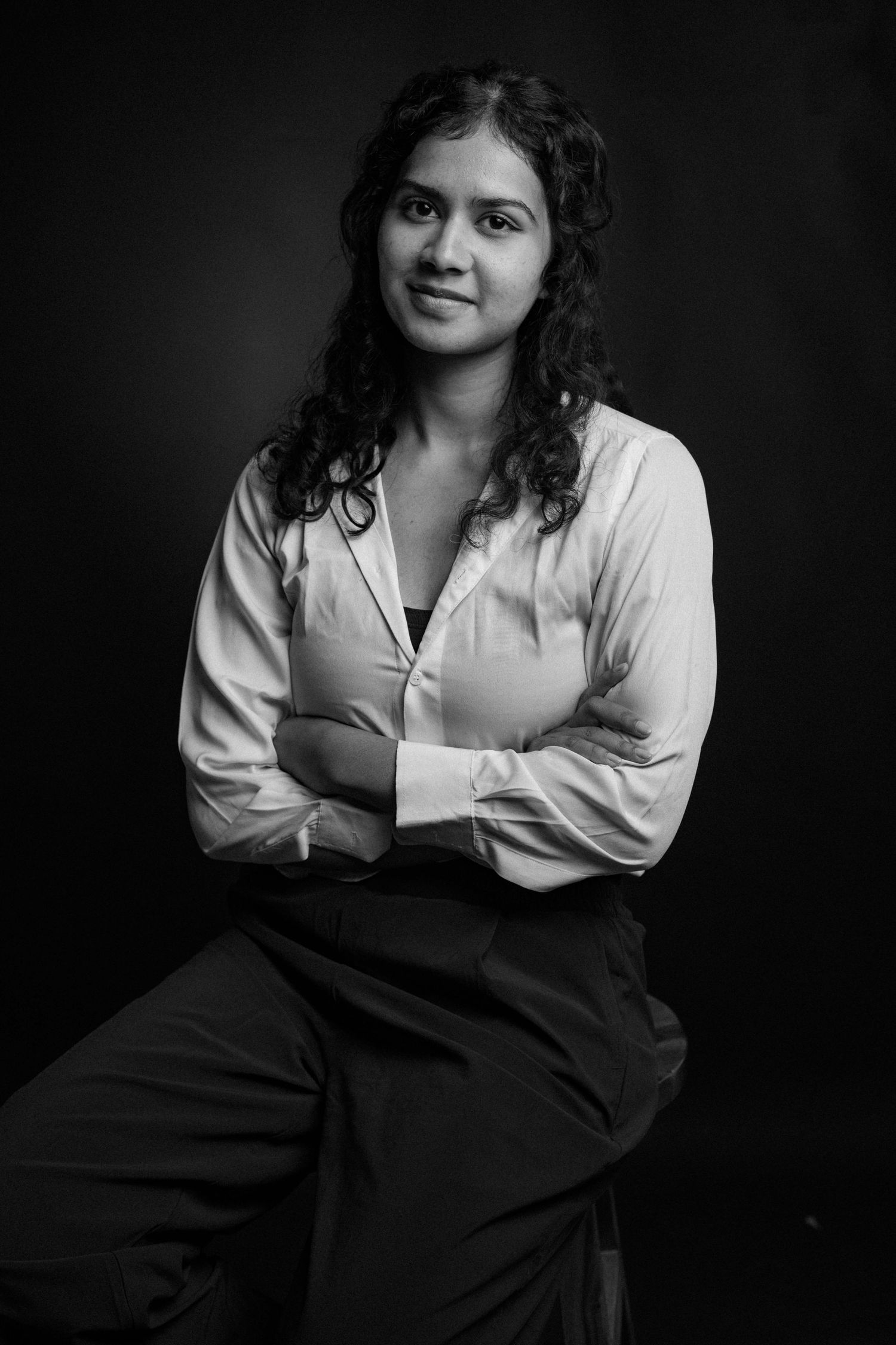Black and white portrait series showing a person in a white shirt and dark clothing against a dark background.