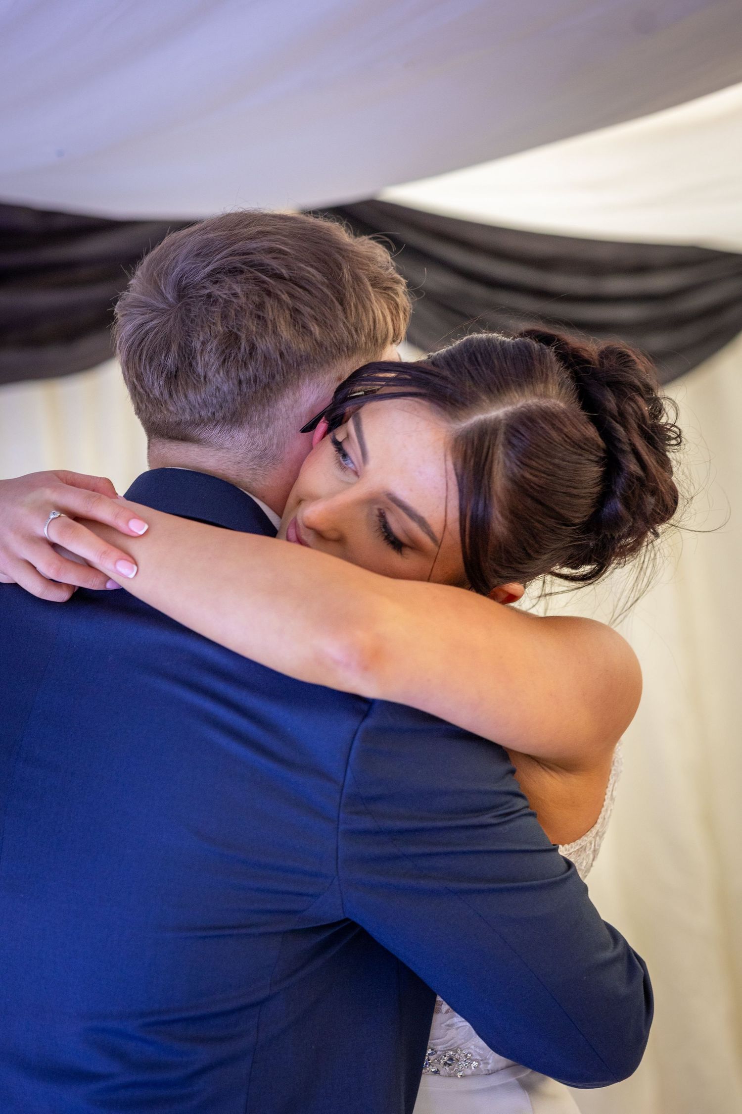 Bride hugs the groom during their first dance in the marquee at alder root golf club, warrington Cheshire. Stuart Morris Photography