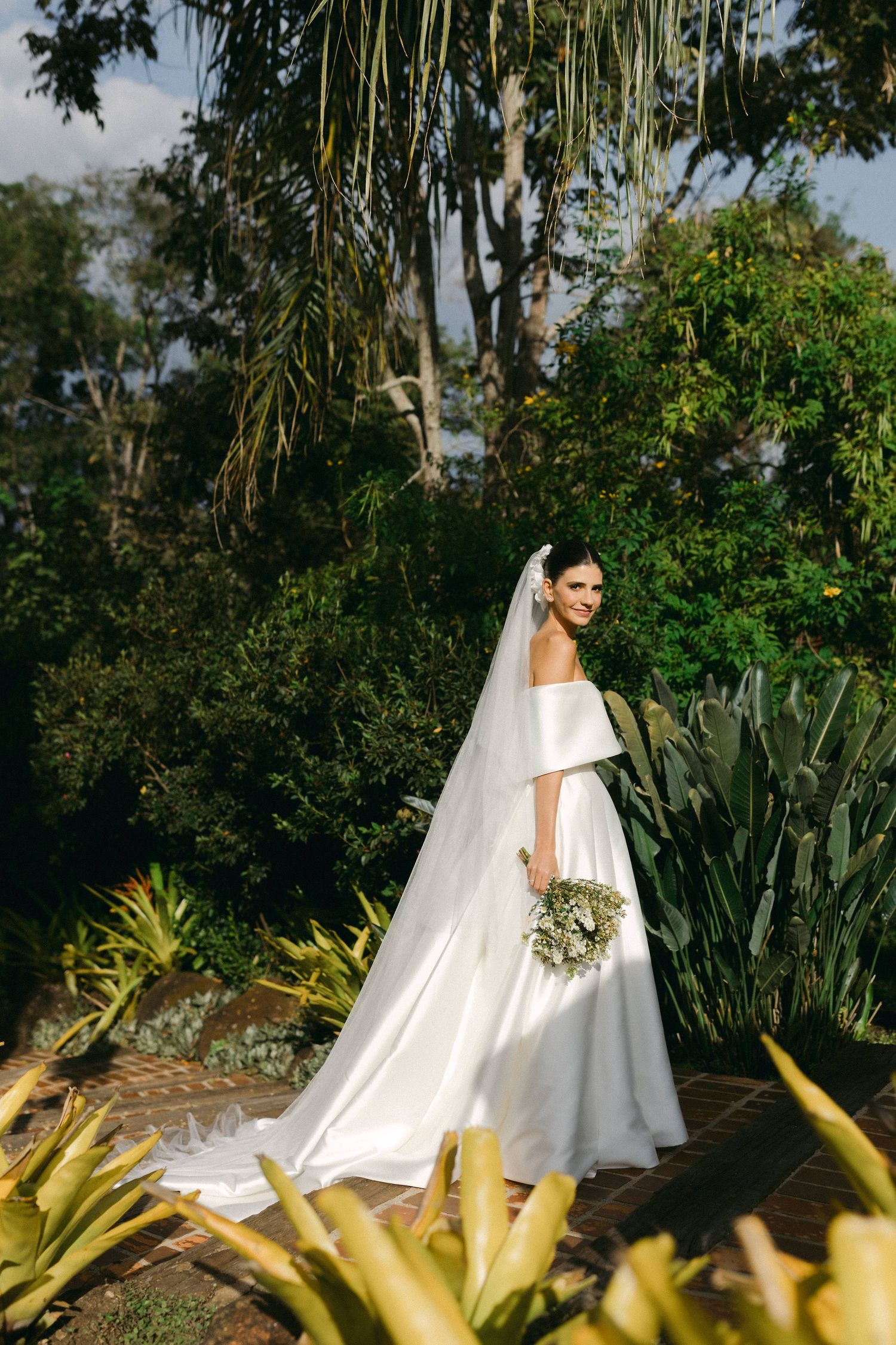 A stunning wedding photo series showing a bride in white against lush tropical greenery and agave plants in an outdoor setting.