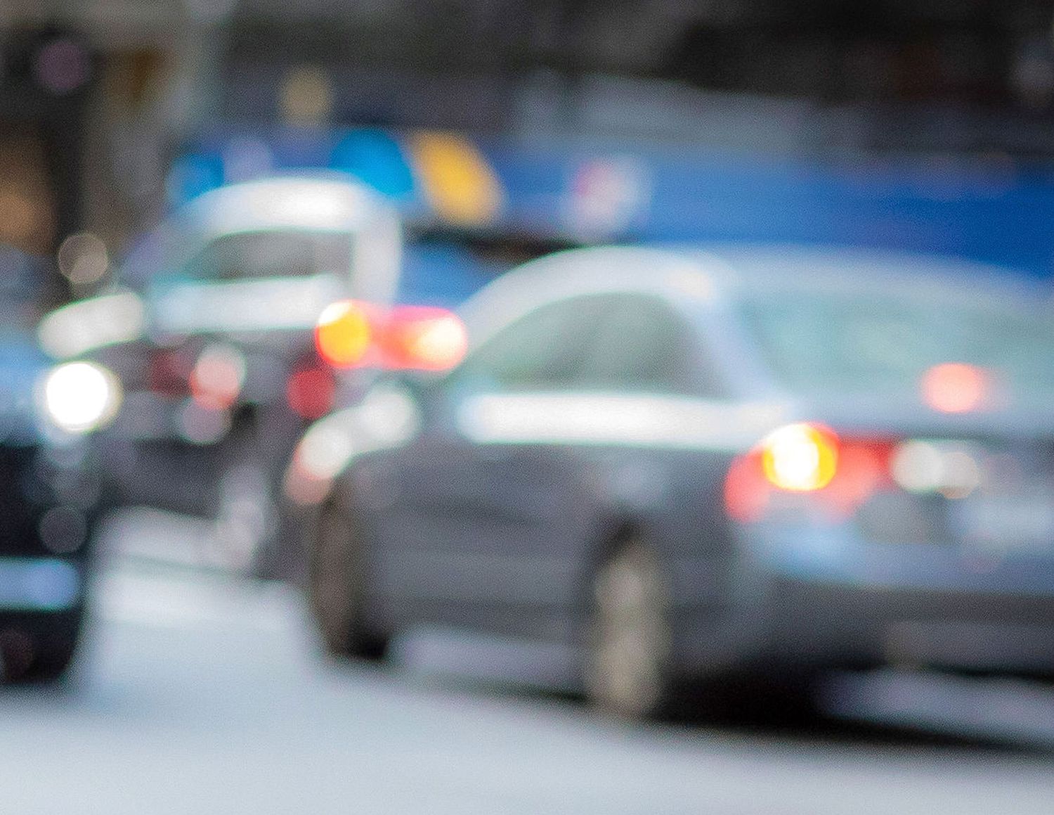 Blurred cars and traffic lights on city street during evening commute.