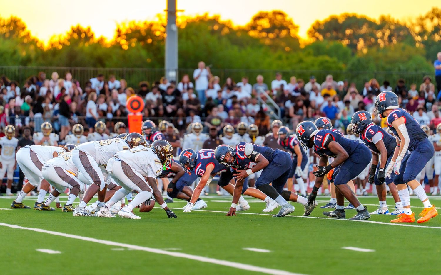Cocoa Bean Bowl, Hershey High school football teams lined up at scrimmage, sunset game with crowd in background, Hershey PA