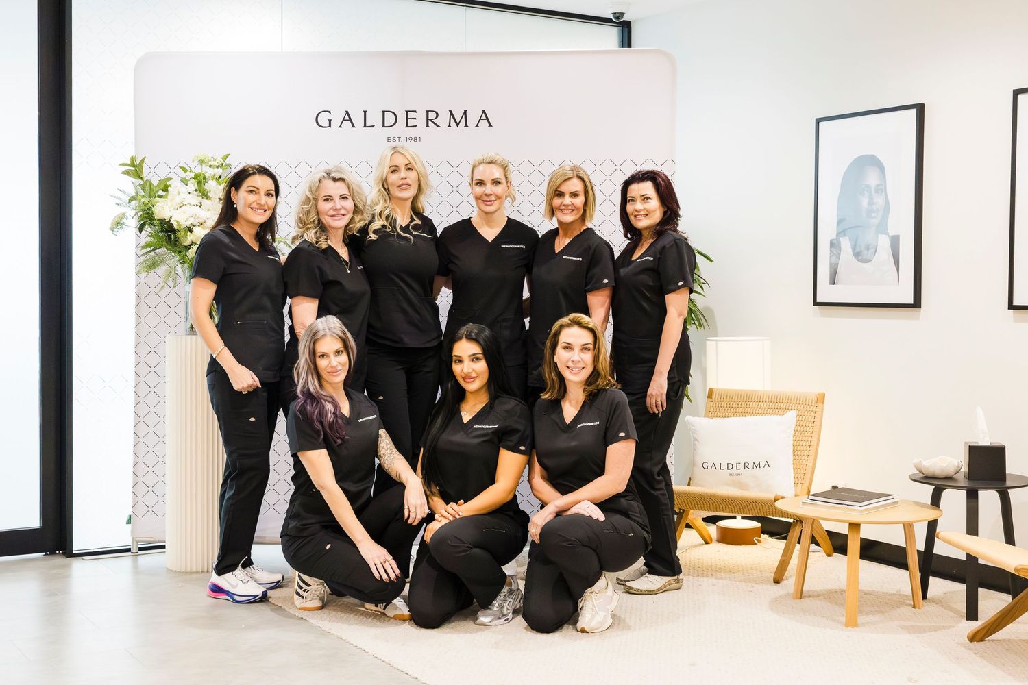 Wollongong Corporate Branding Photographer. Group of aesthetics professionals in black uniforms posing together in a modern clinic setting.
