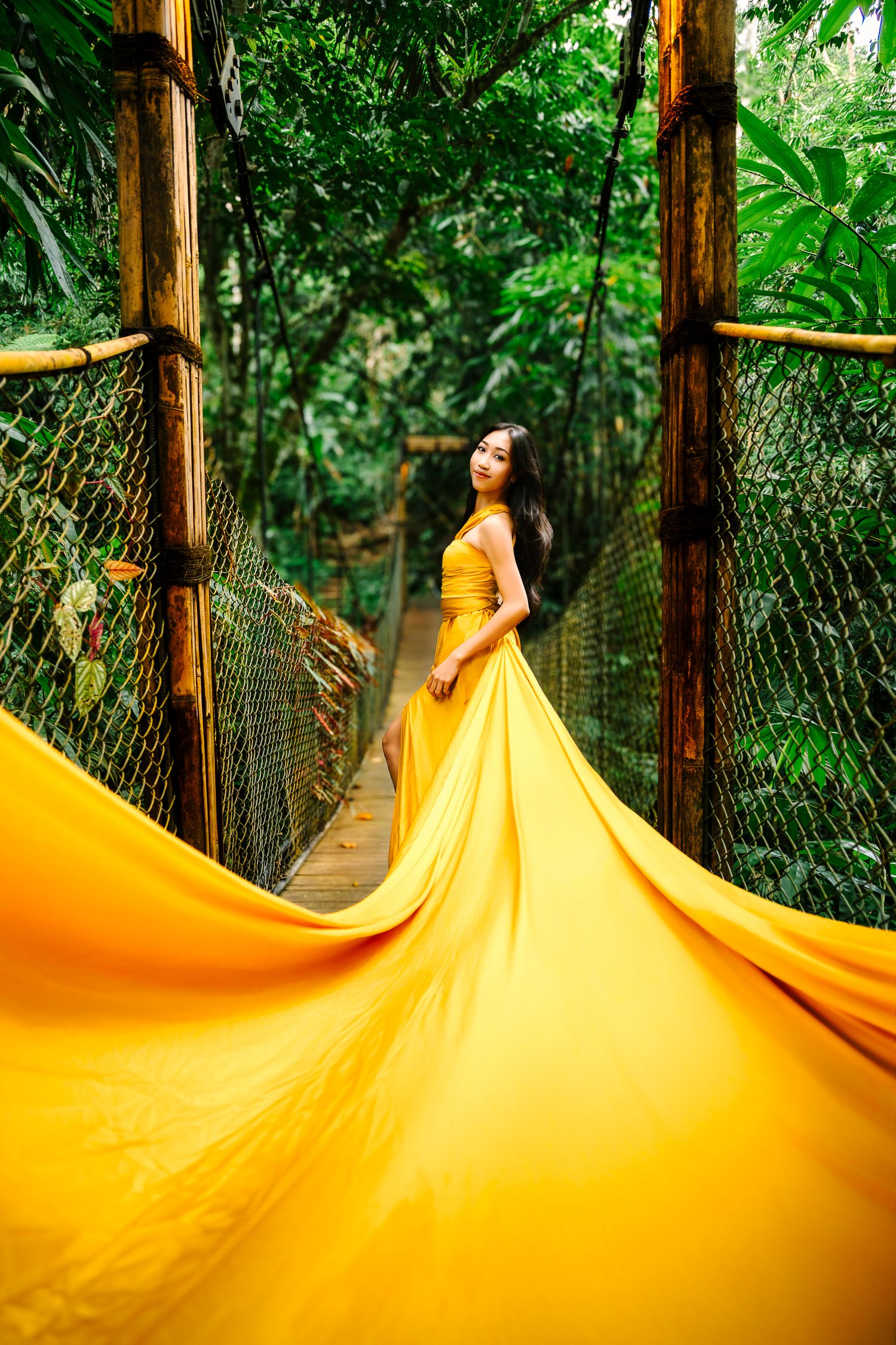 Wollongong Flying Dress Photographer. Girl in yellow Flying Dress on a bridge at Akohara Resort Bali.