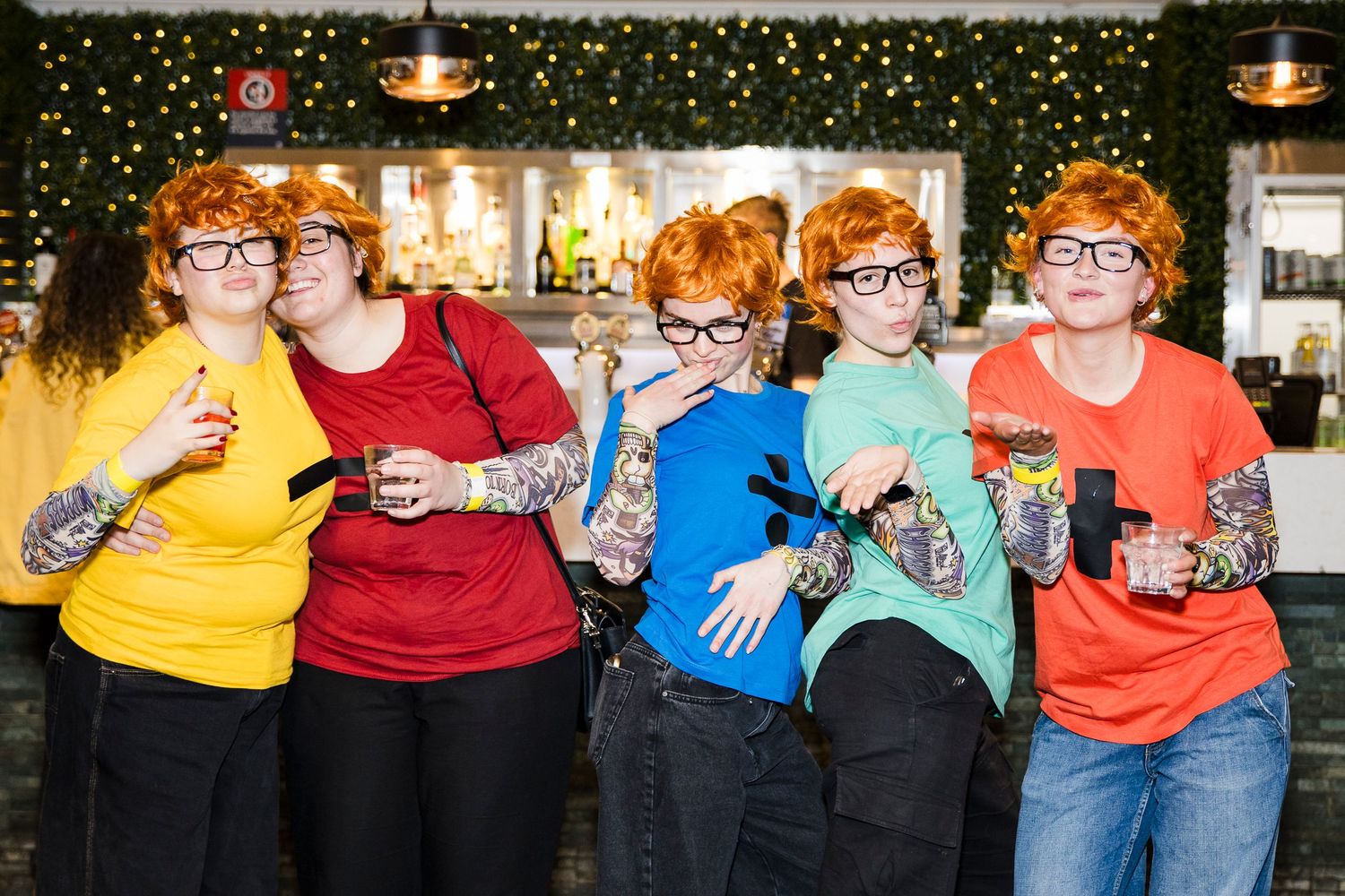 Five people in matching Ed Sheeran costumes with red wigs, glasses, and tattoo sleeves at a party. Wollongong Event Photographer