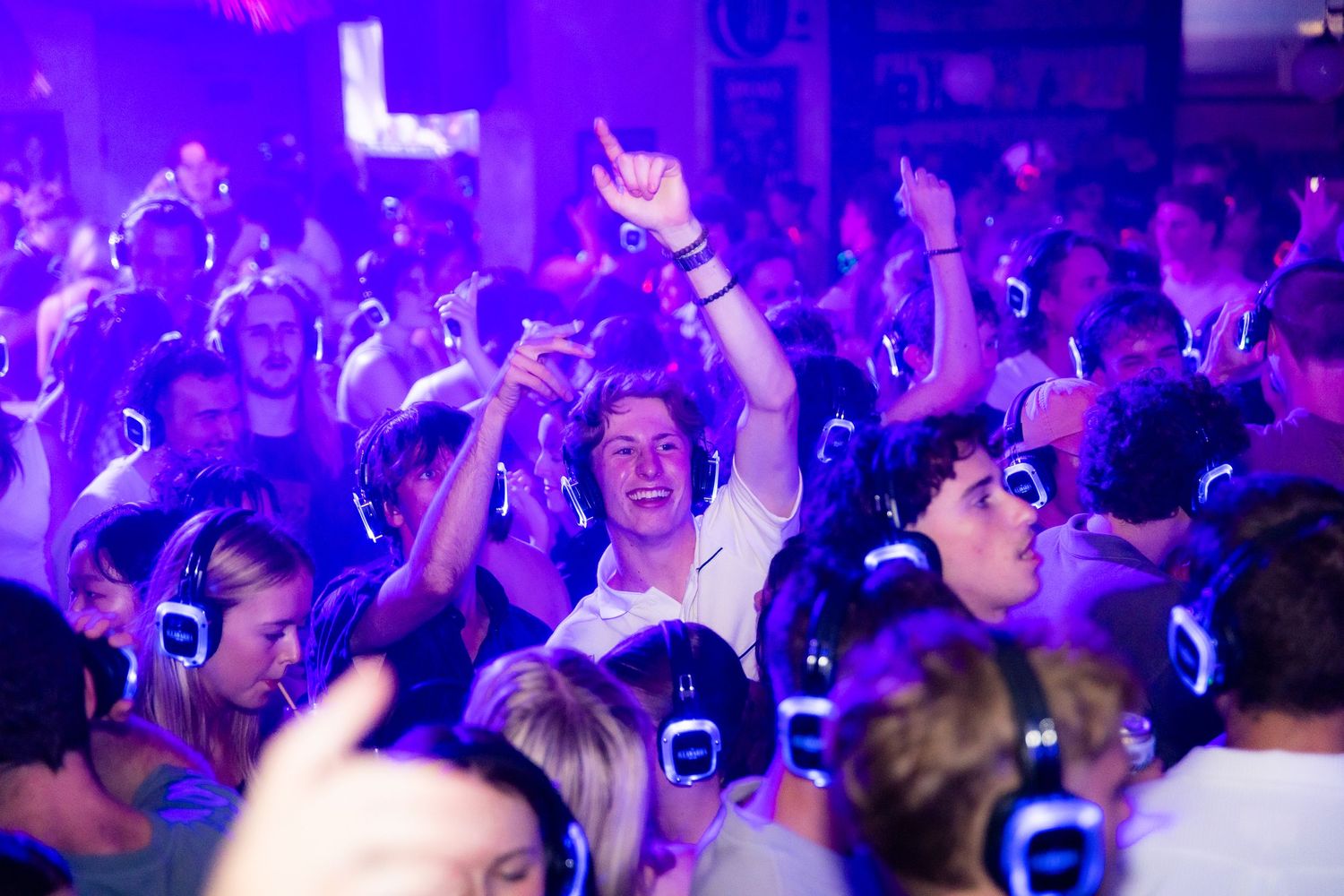 Wollongong Event Photographer. Crowd of young people at Illawarra Hotel silent disco party under purple lights.
