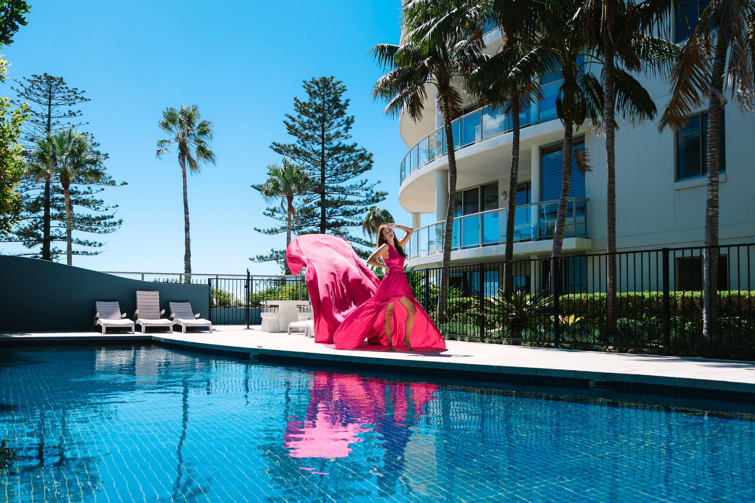 Wollongong Flying Dress Photographer. Woman in a pink Flying Dress beside a pool.