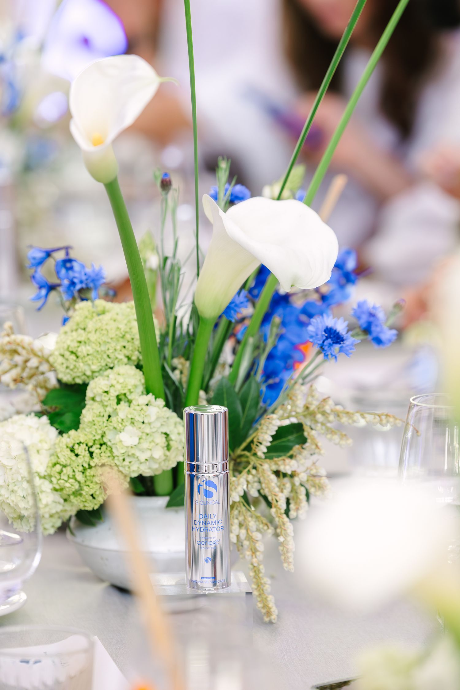 Elegant floral centerpiece with a skincare product on a table. Wollongong Corporate Branding Photographer