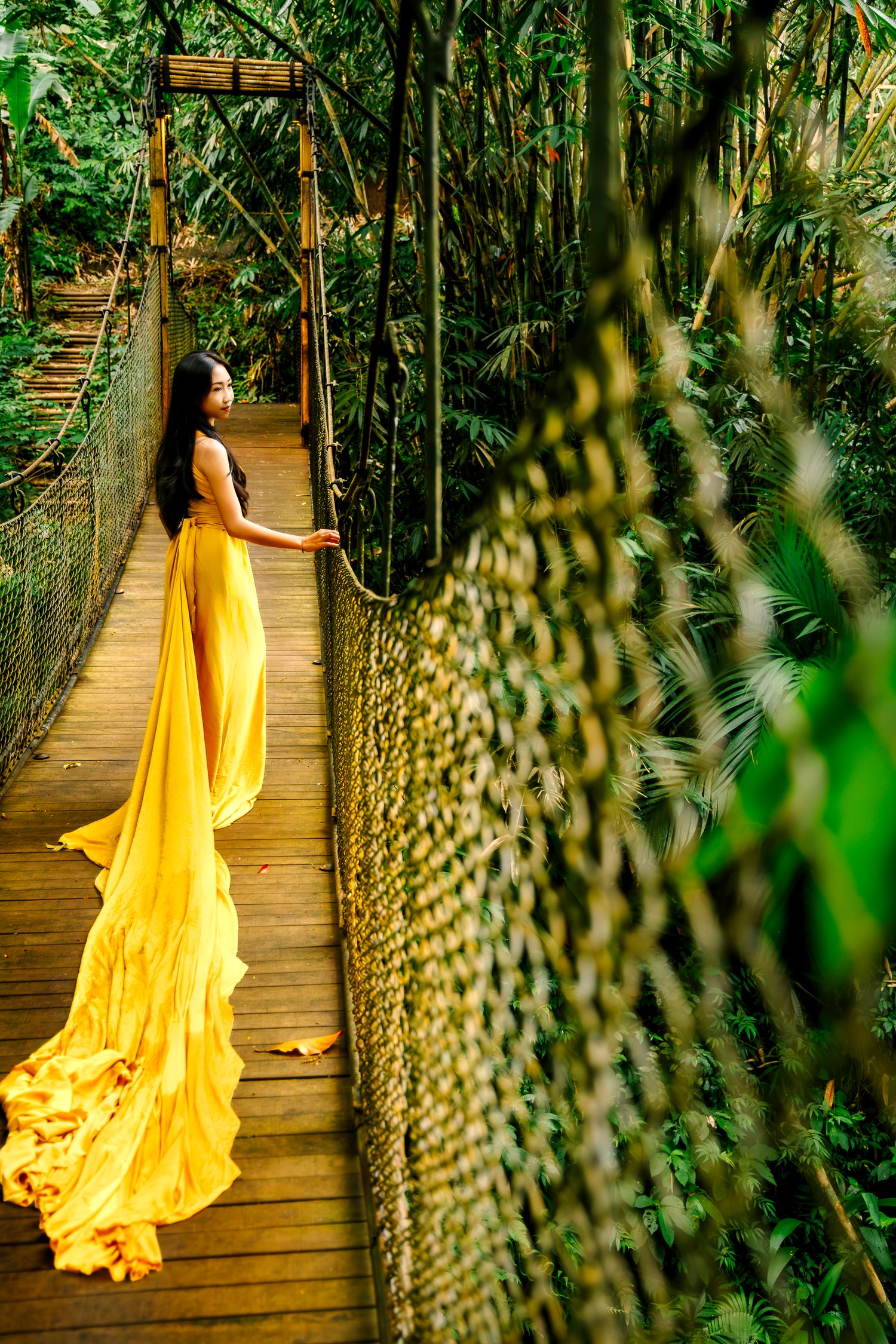 Wollongong Flying Dress Photographer. Girl in yellow Flying Dress on a bridge at Akohara Resort Bali.