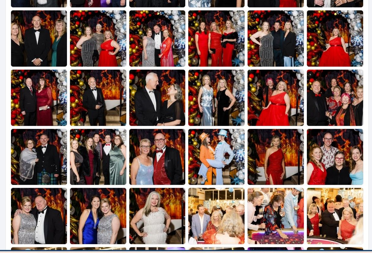 Elegant guests in formal attire pose for photos at a glamorous holiday gala event with festive decorations. Wollongong Event Photographer
