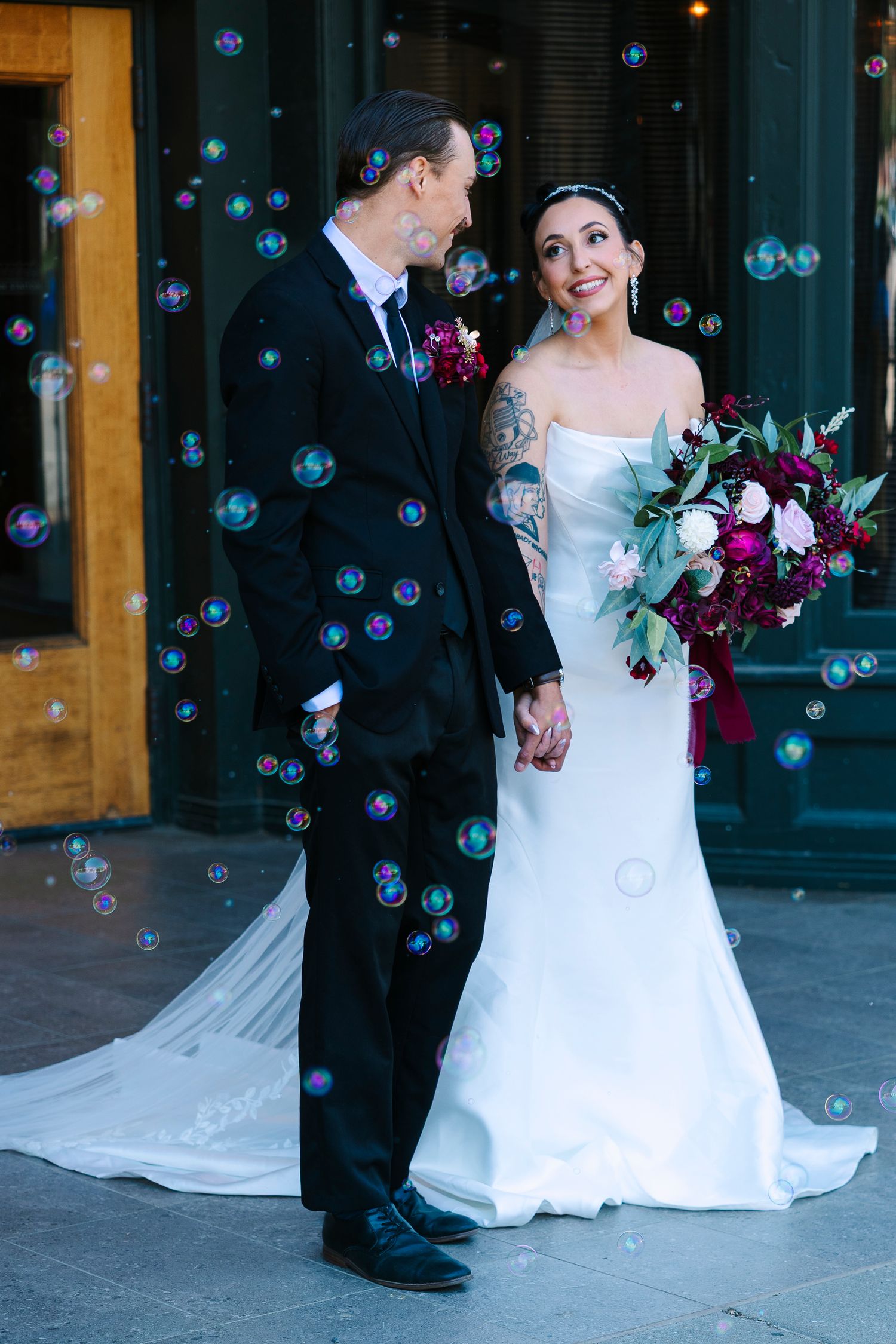 Bride and groom hold hands surrounded by bubbles. Wollongong Wedding Photographer