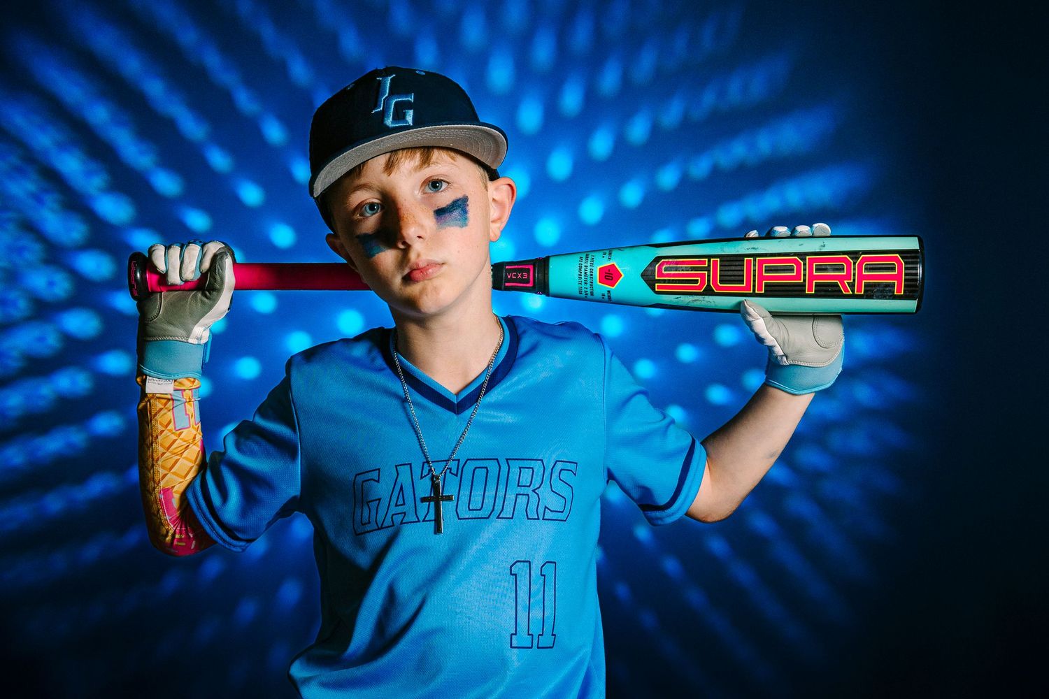 Wollongong Portrait Photographer. Young baseball player in blue Gators jersey poses with a Supra bat over his shoulder.