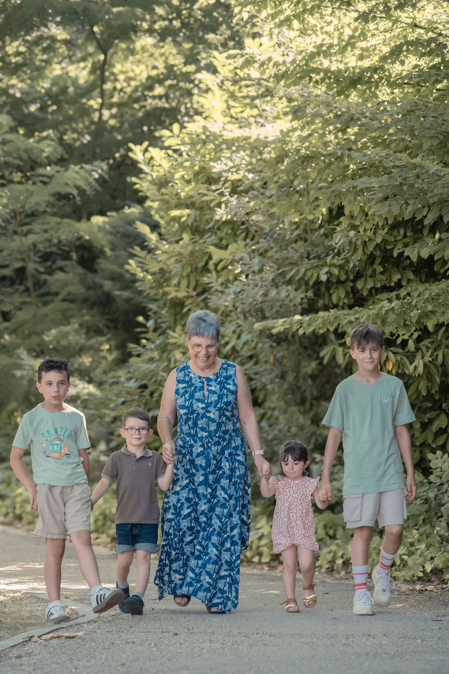 A group walk along a tree-lined path on a sunny summer day.