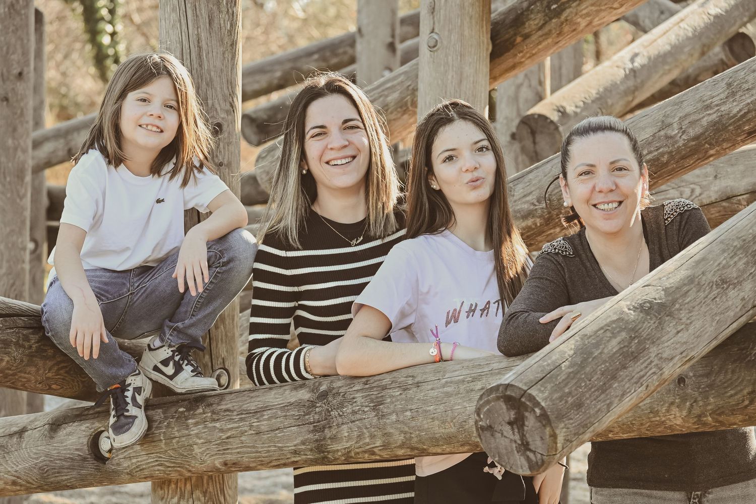 A group sits together on rustic wooden steps outdoors during a warm sunny afternoon.