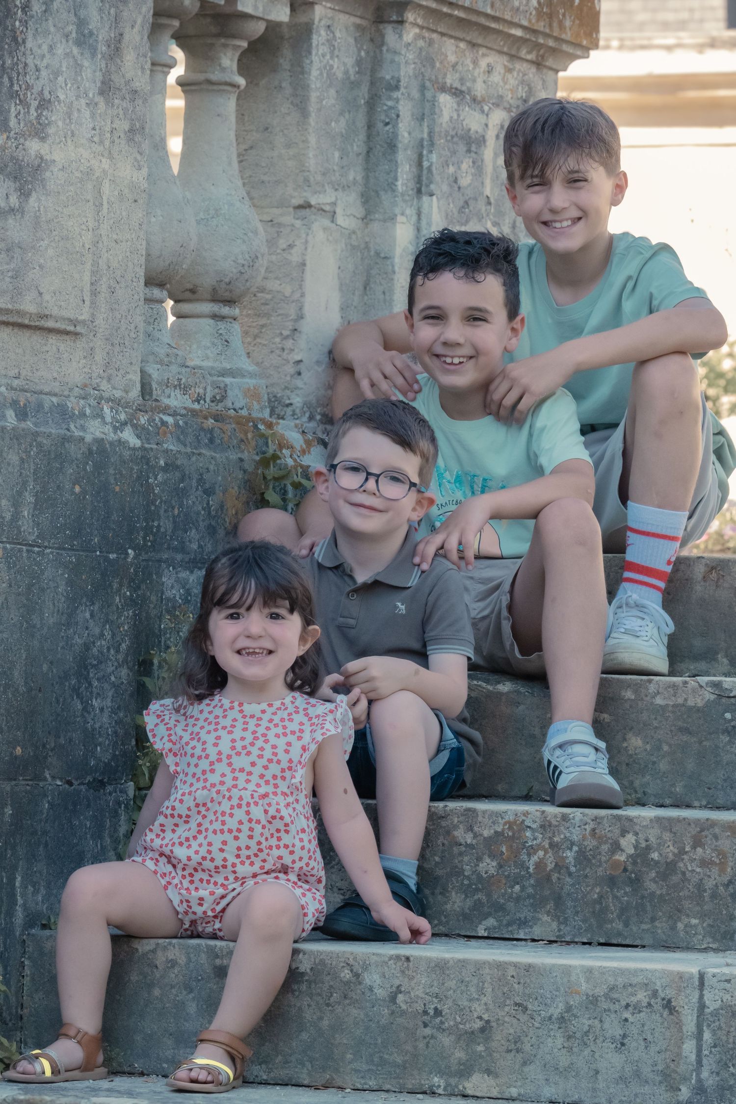 Children gathered on historic stone steps during an outdoor photo shoot.