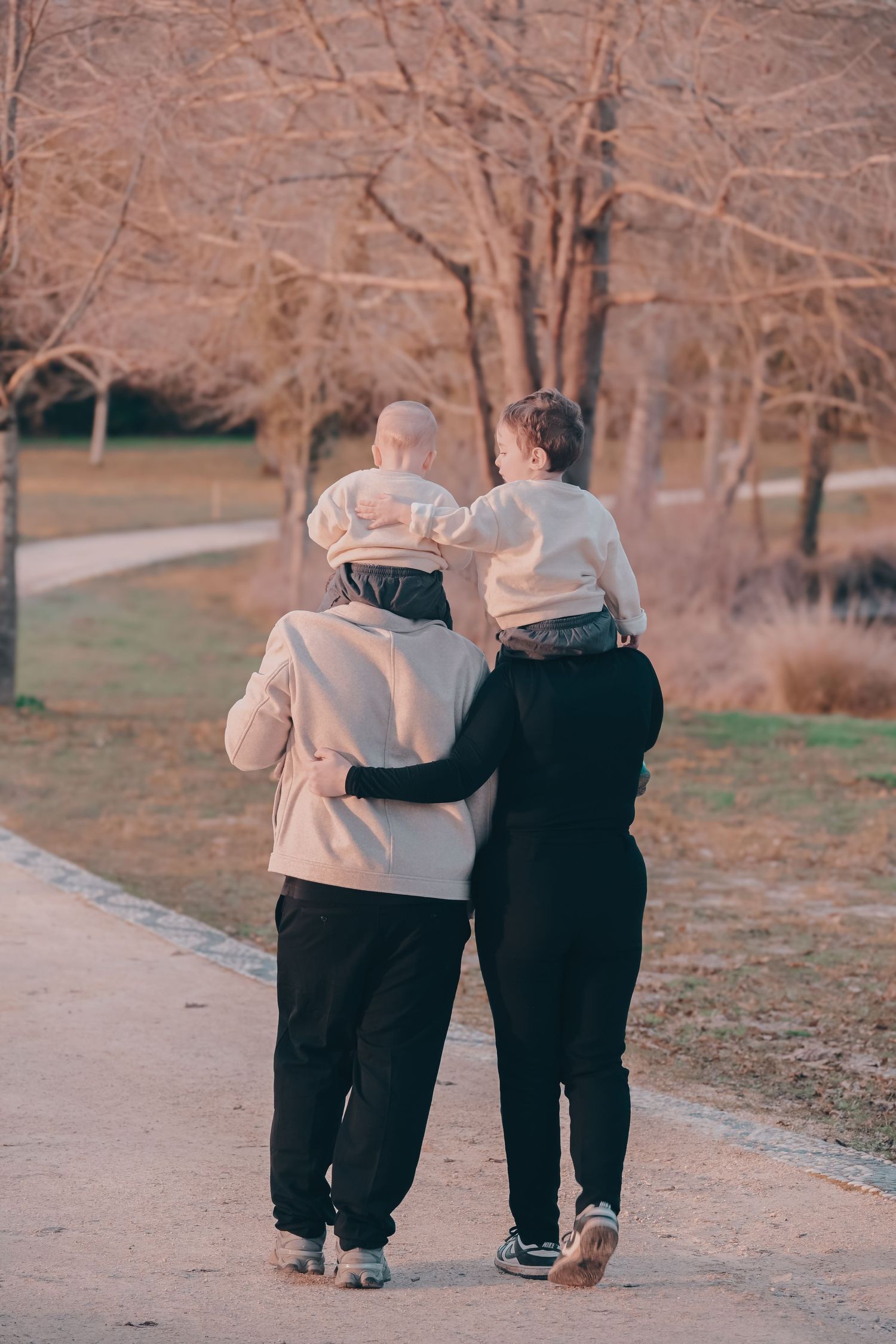 Two people walking together on an autumn path wearing matching outfits.