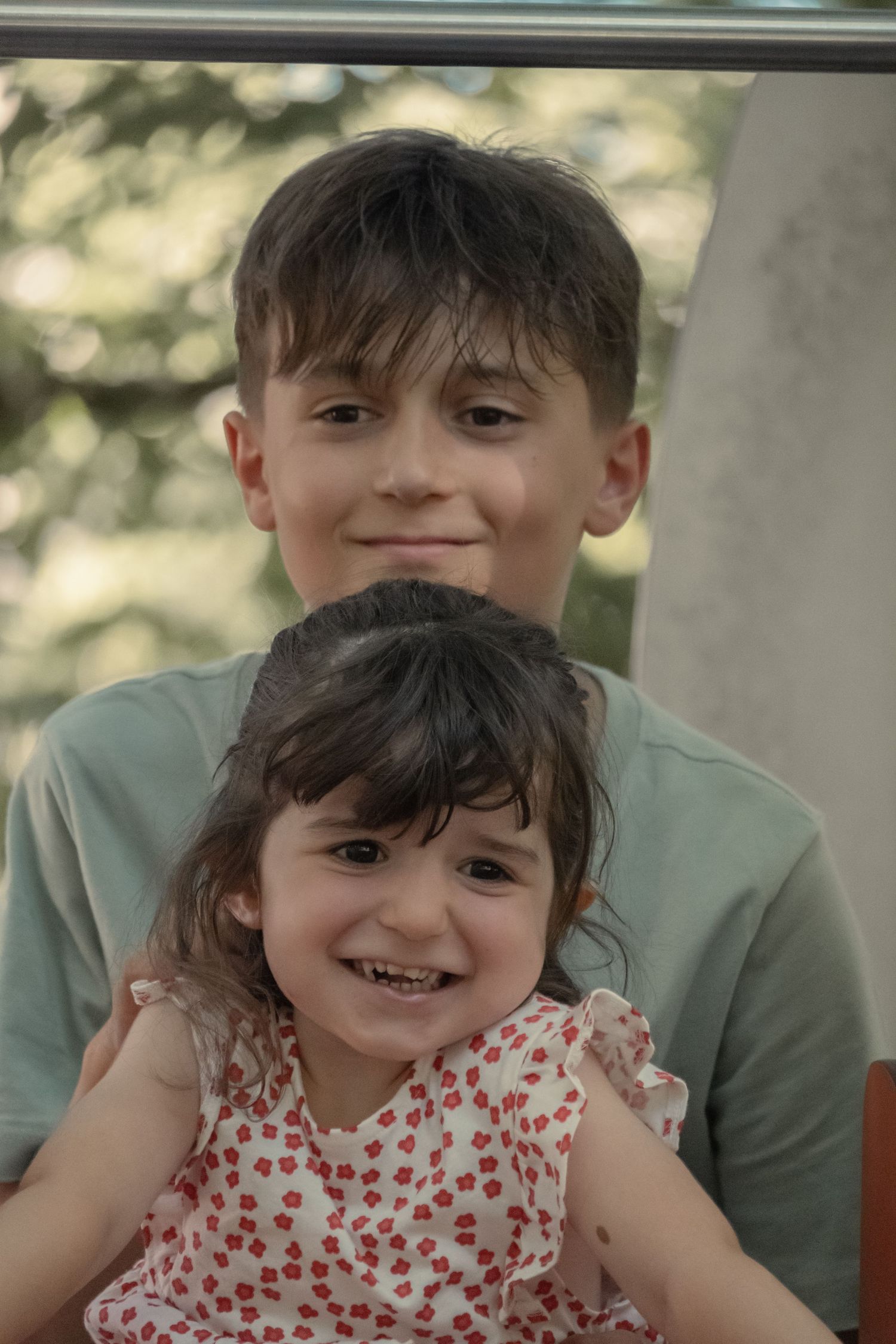 Three candid photos showing joyful family moments as an older sibling plays with their younger sibling outdoors.