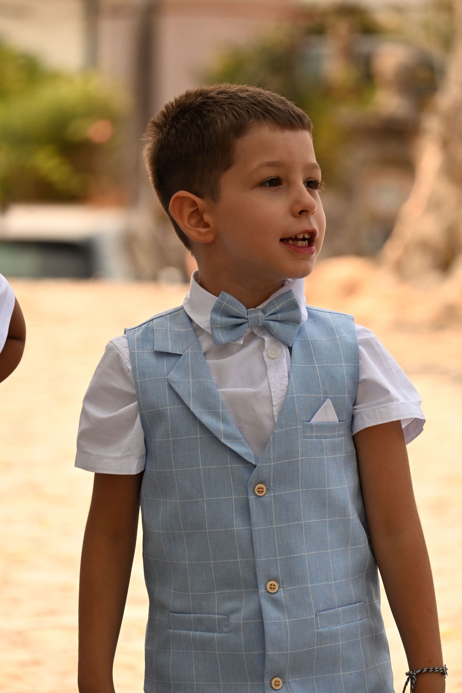 A collage of photos showing a child wearing a light blue vest and white shirt against a soft blurred background.