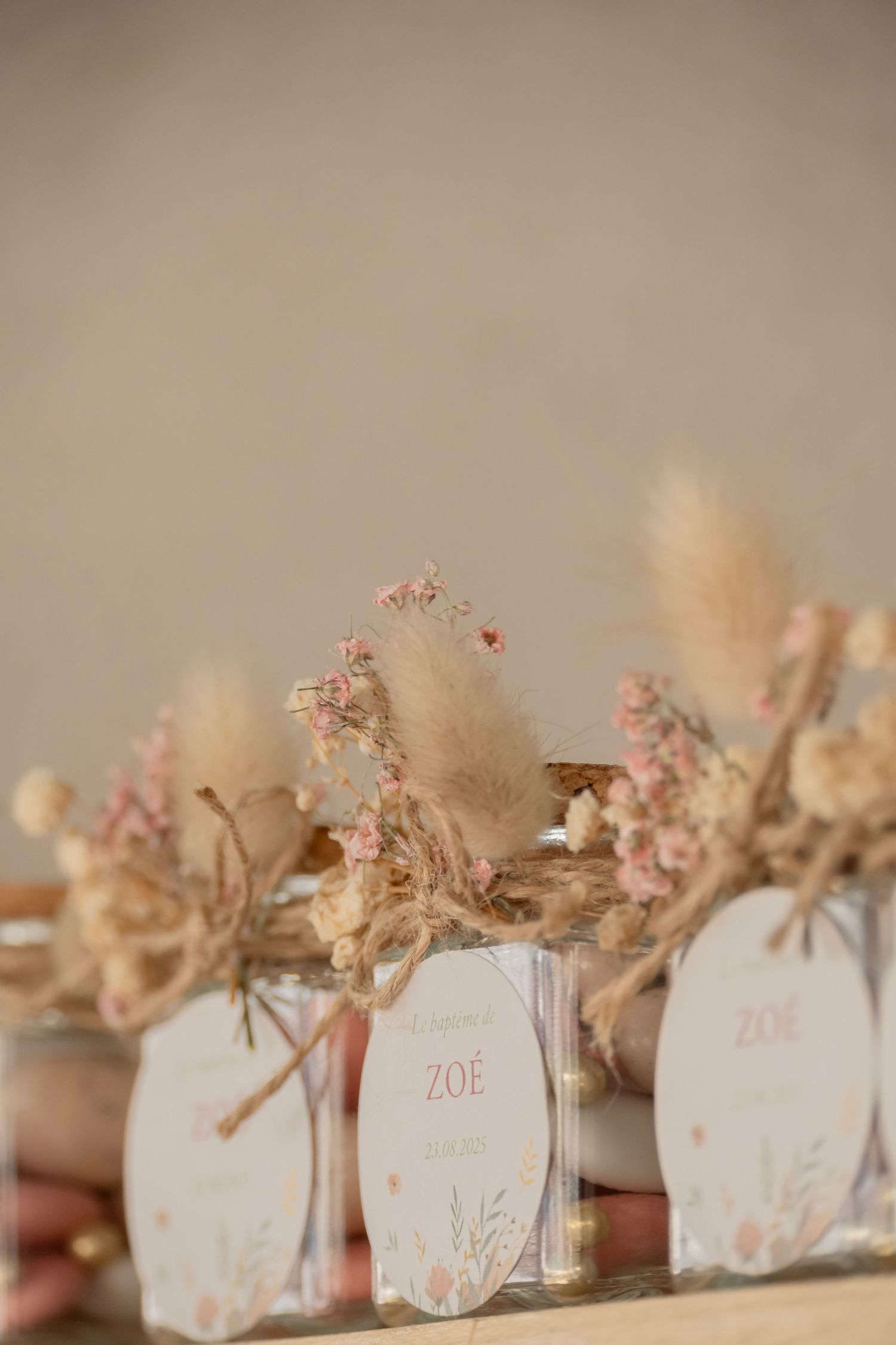 Delicate wedding place cards decorated with dried flowers and 'Zoe' name tags in soft pastel colors.