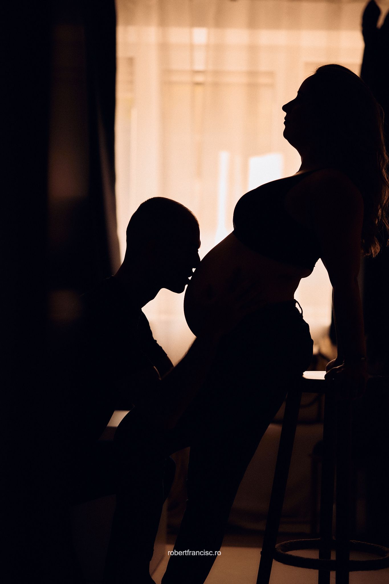 Silhouettes of multiple people drinking at a bar counter in dim lighting.