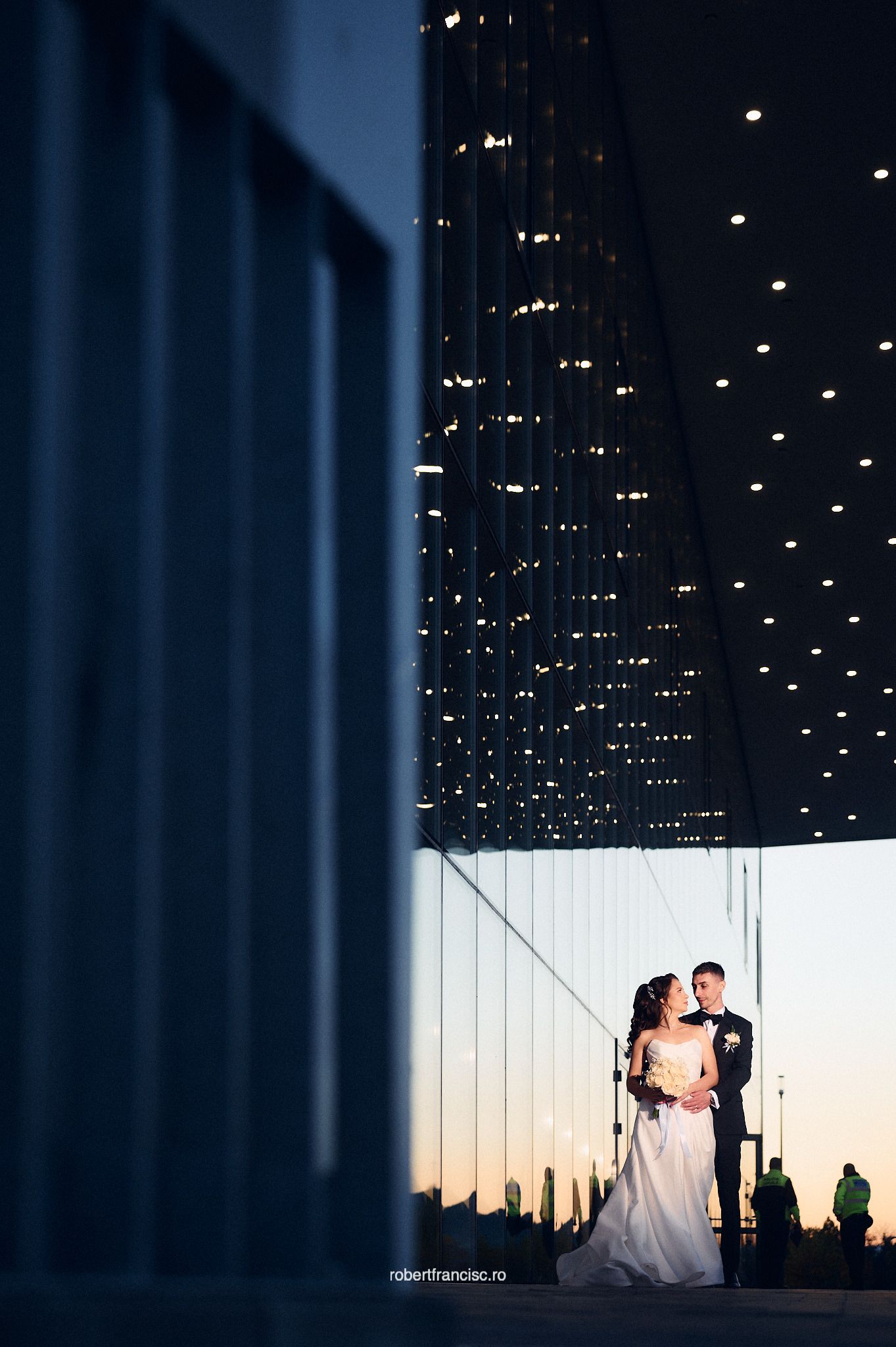 Silhouettes of a couple dancing against a starlit ceiling at an elegant indoor venue during their wedding celebration.