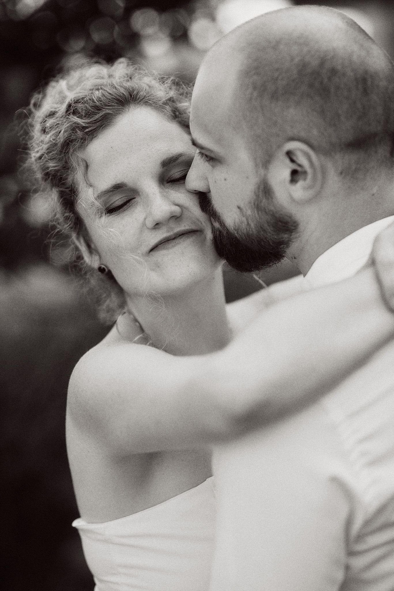 An intimate black and white portrait capturing a tender moment between newlyweds.