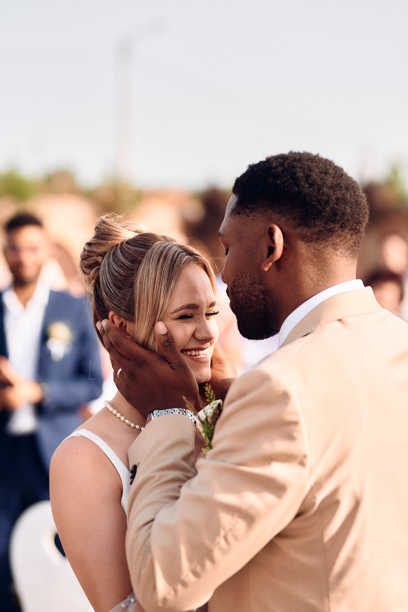 Intimate wedding moment captured outdoors with couple in formal attire.
