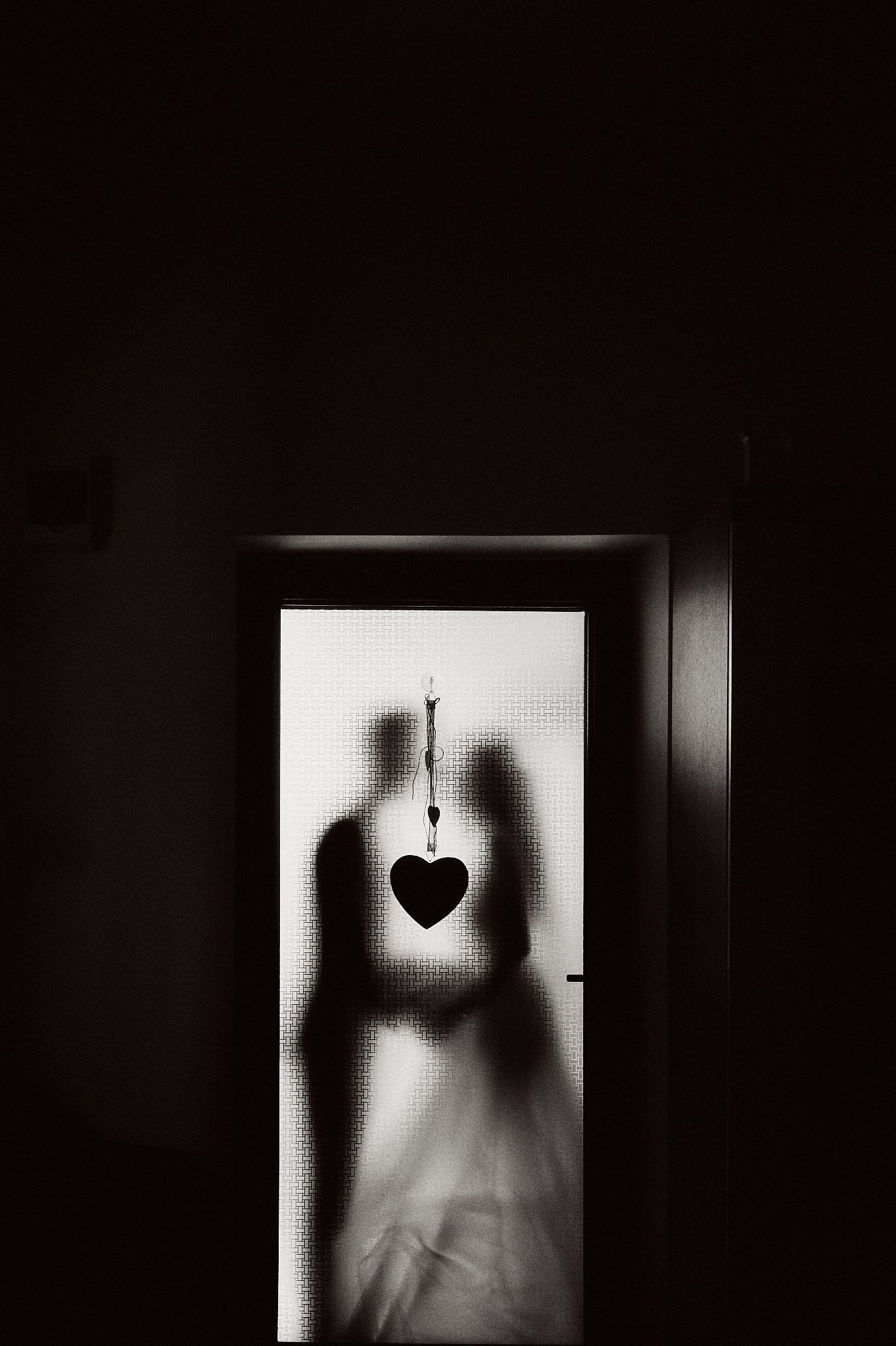 Artistic silhouette of a couple with a heart decoration creating a romantic shadow effect.