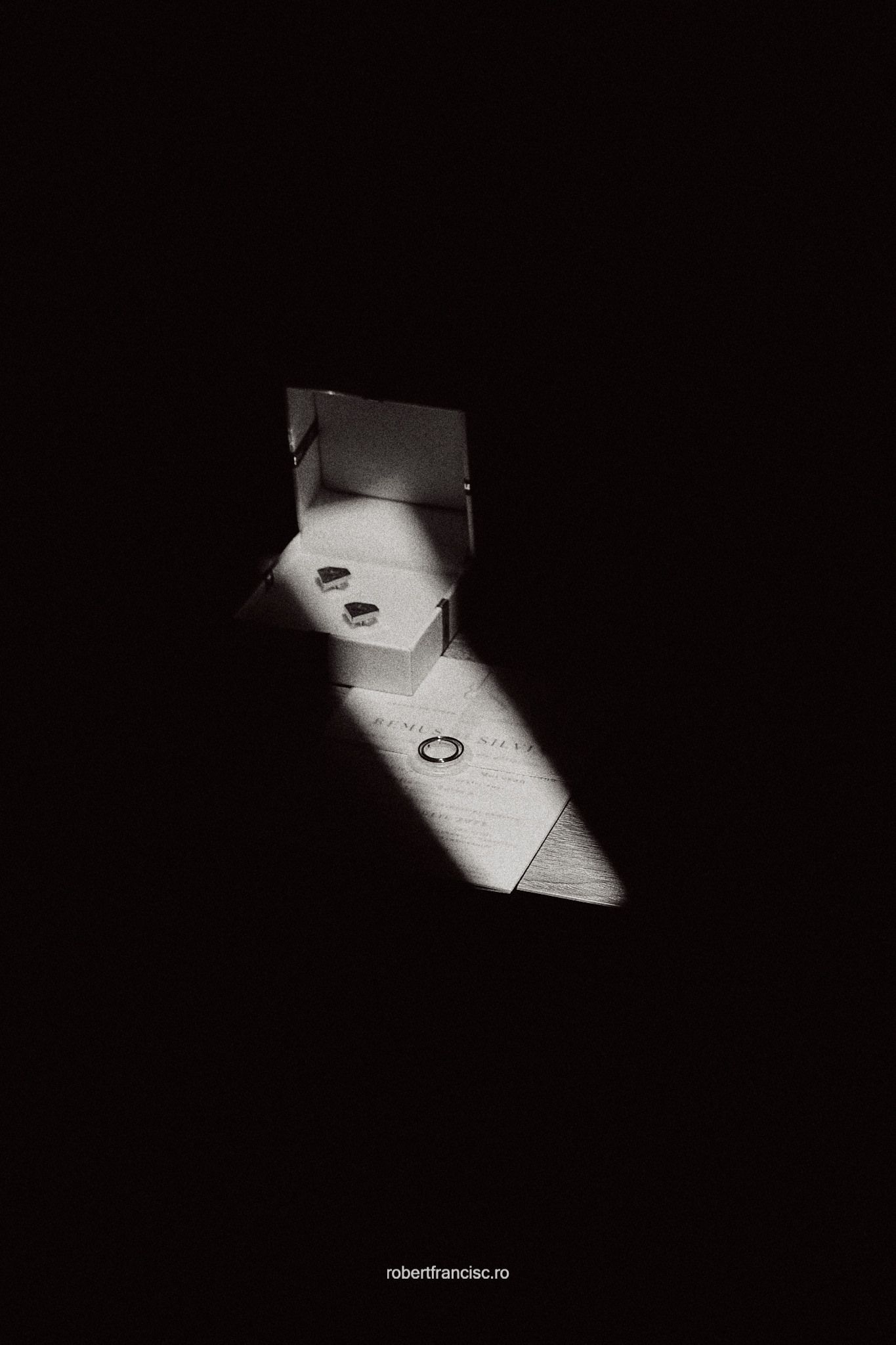 Dramatic black and white photograph of light casting geometric shadows on a floor through a doorway or window.