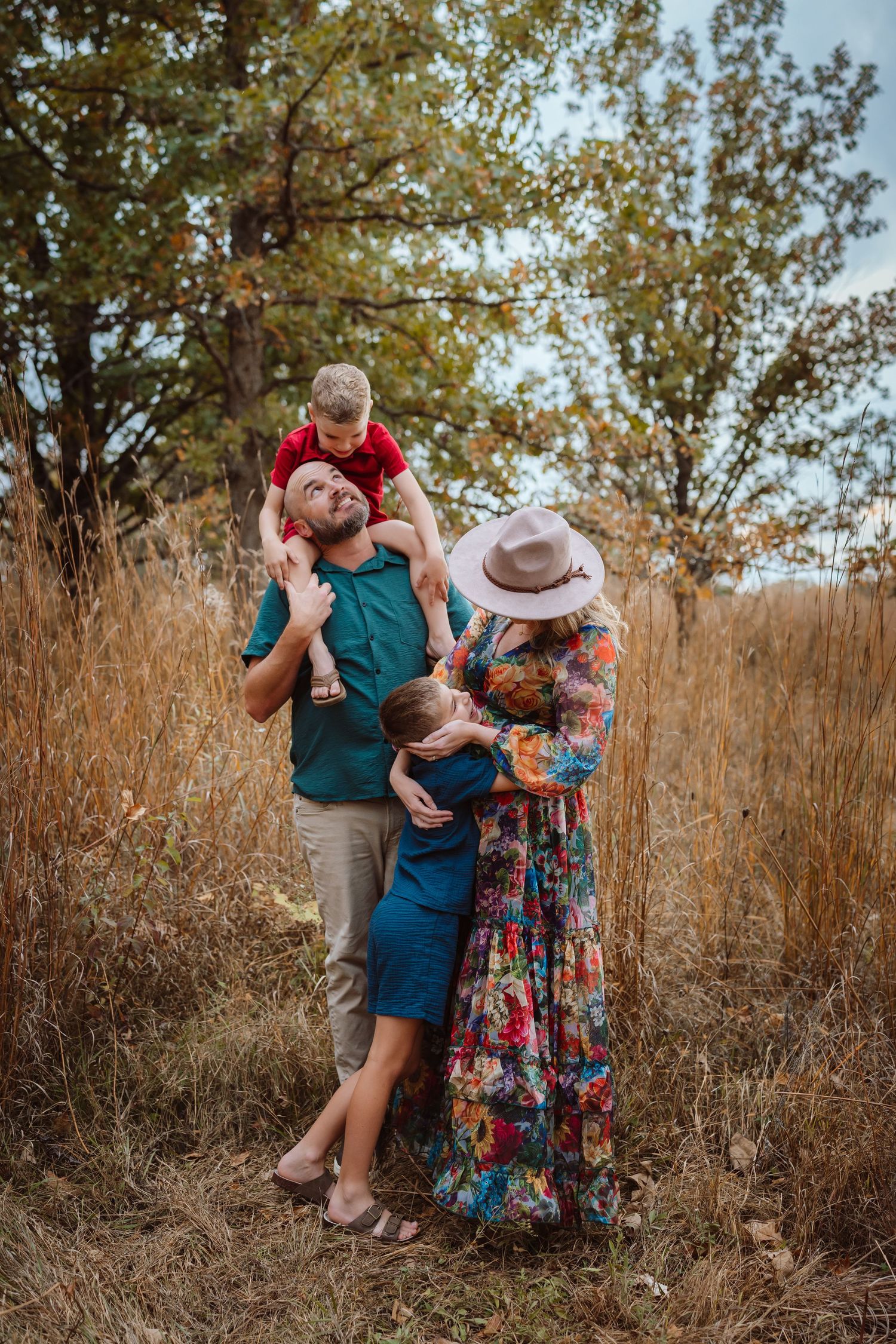 Family embraces as in a Des Moines area park at sunset during a lifestyle family photo session.