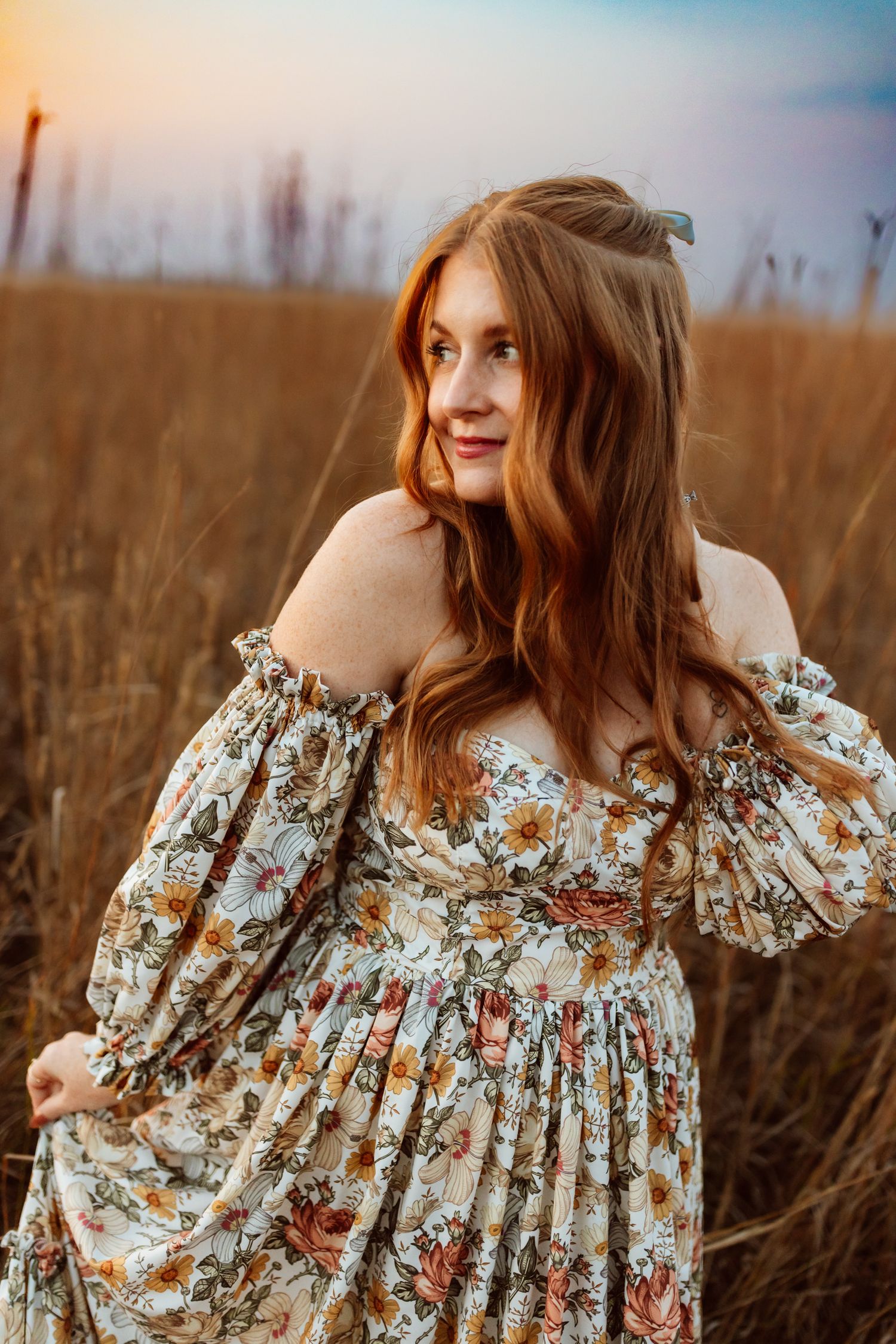 Woman stands in field in a Des Moines area park at sunset during a lifestyle family photo session.