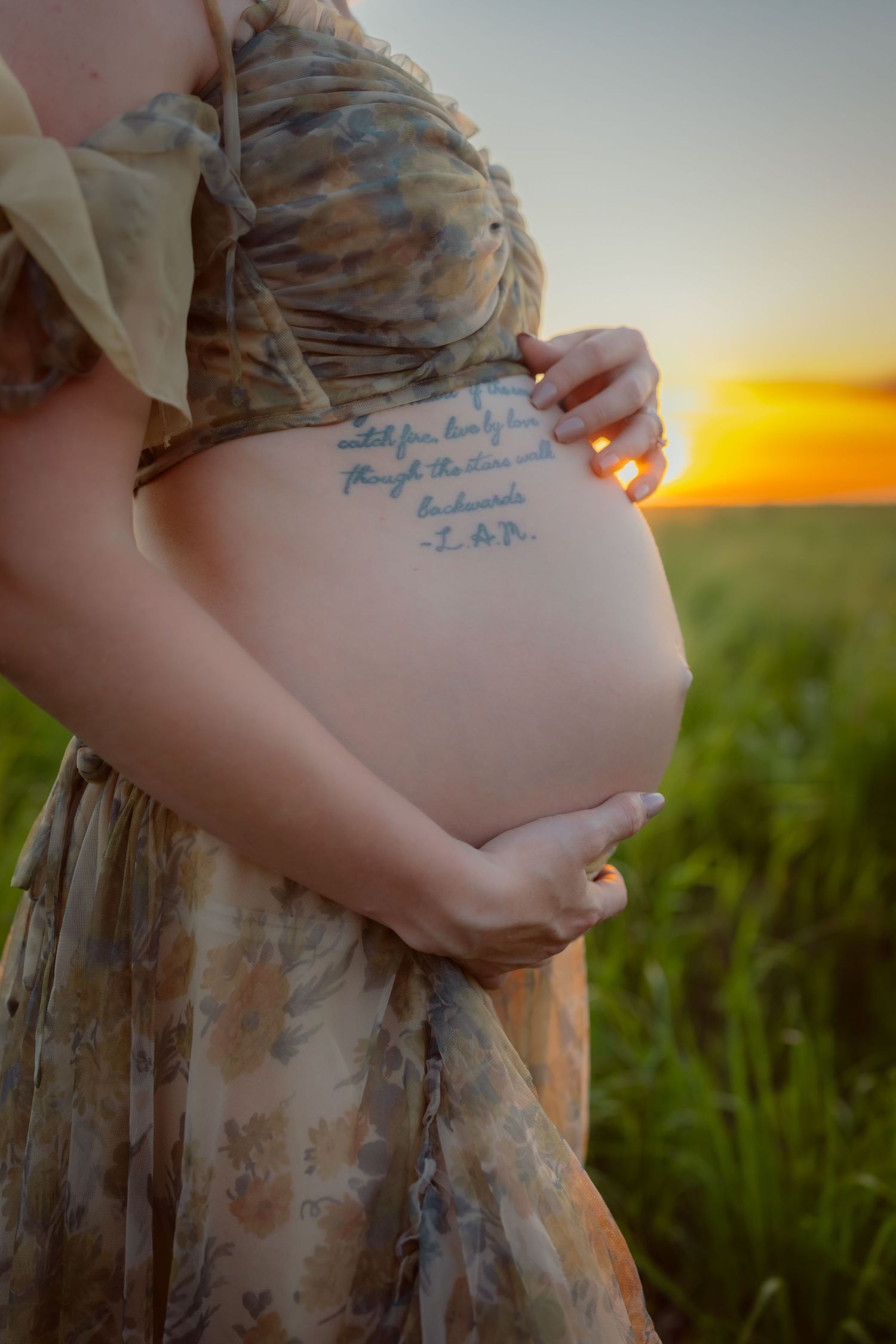 Pregnant woman in a Des Moines area field at sunset during lifestyle maternity photo session.