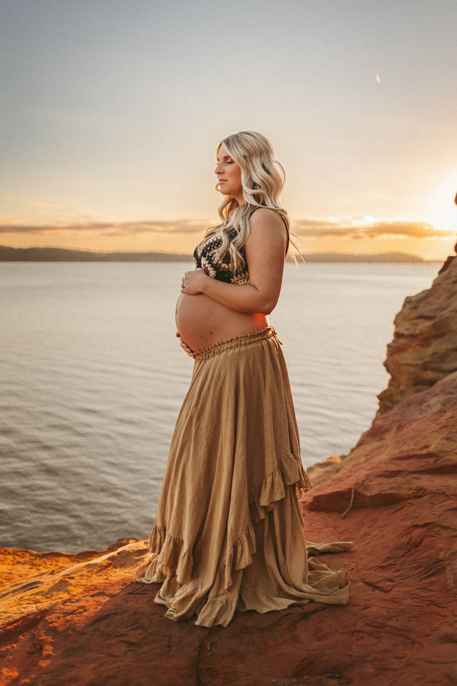 Pregnant woman in a Des Moines area lake at sunset during lifestyle maternity photo session.