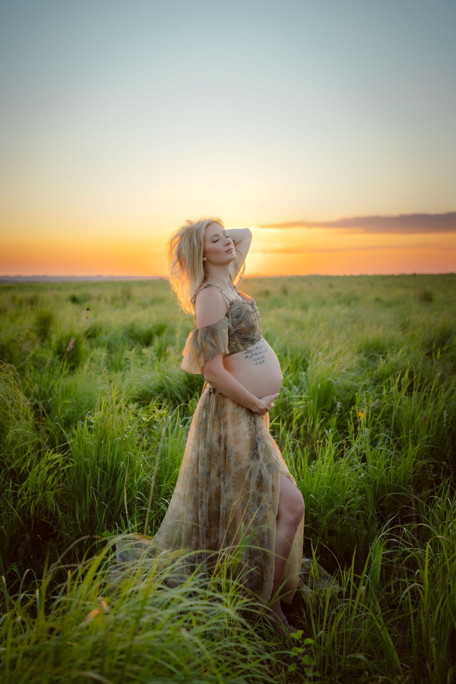 Pregnant woman in a Des Moines area field at sunset during lifestyle maternity photo session.