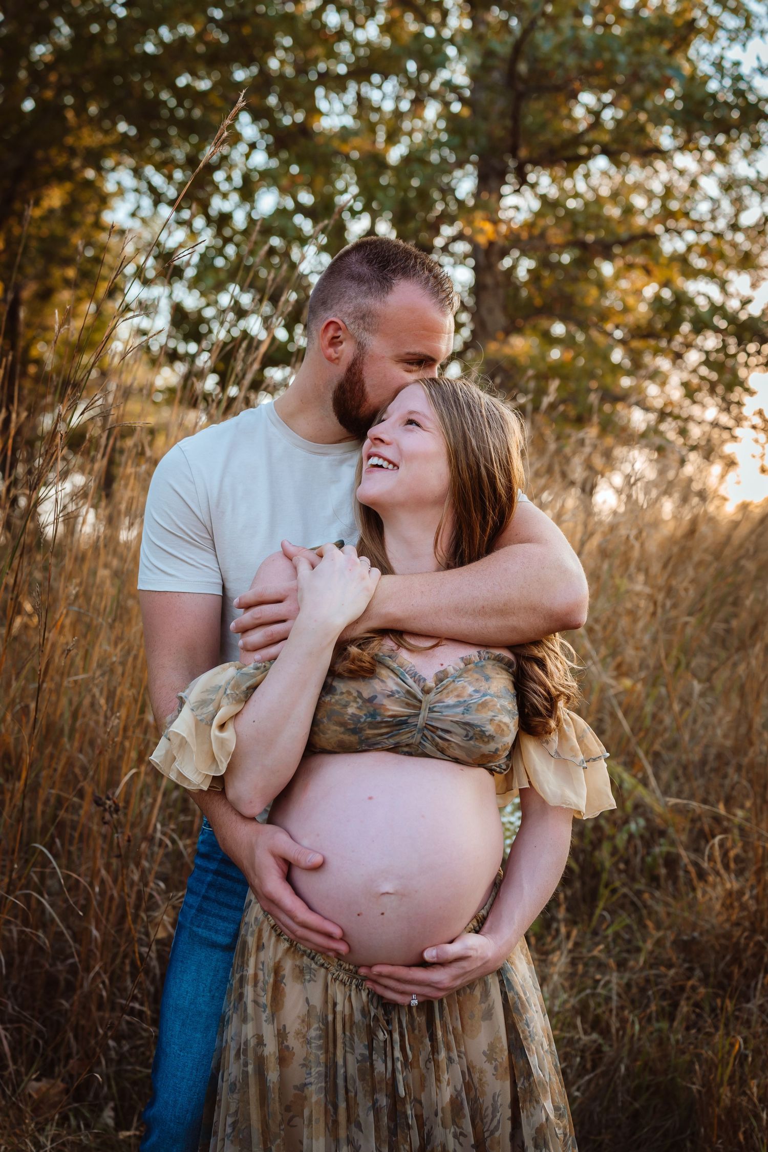 Pregnant woman in a Des Moines area field at sunset during lifestyle maternity photo session.
