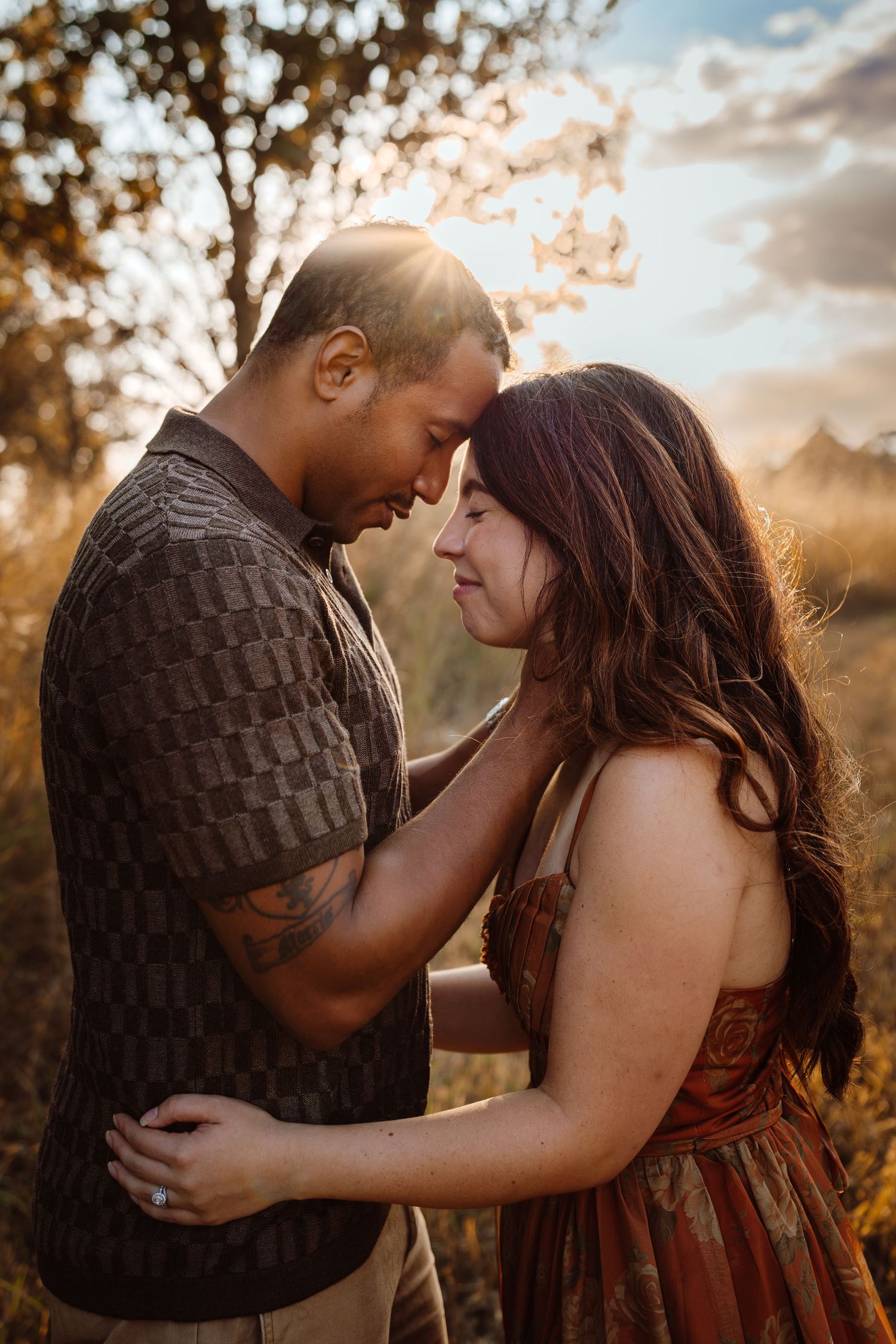 Couple hugs in a Des Moines area park at sunset during a lifestyle family photo session.