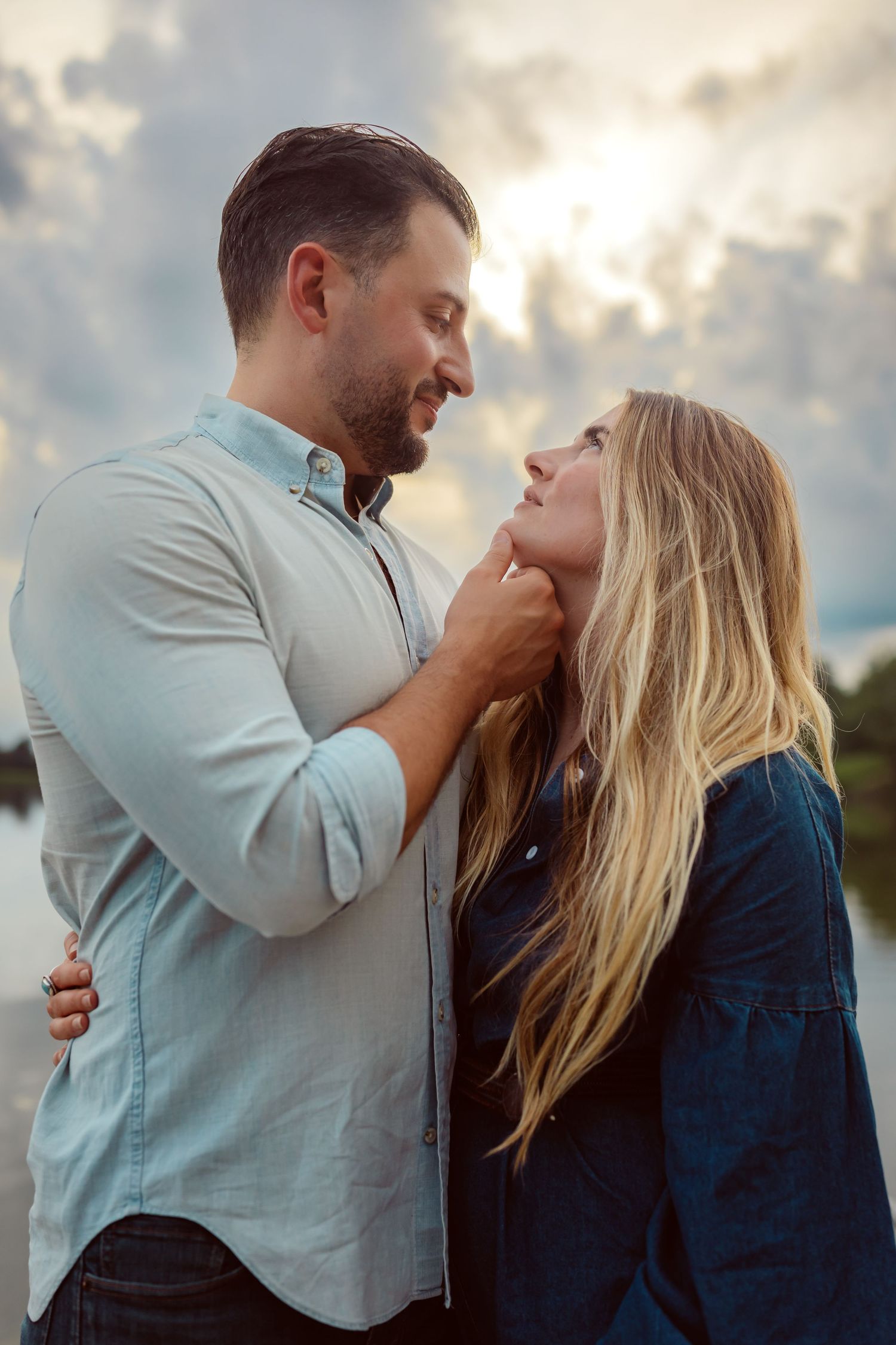 Couple hugs in a Des Moines area park at sunset during a lifestyle family photo session.