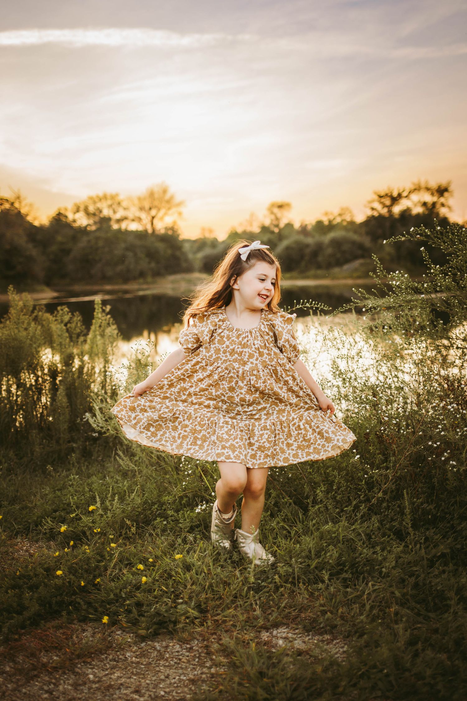 Young girls dances in a Des Moines area park at sunset during a lifestyle family child milestone photo session.