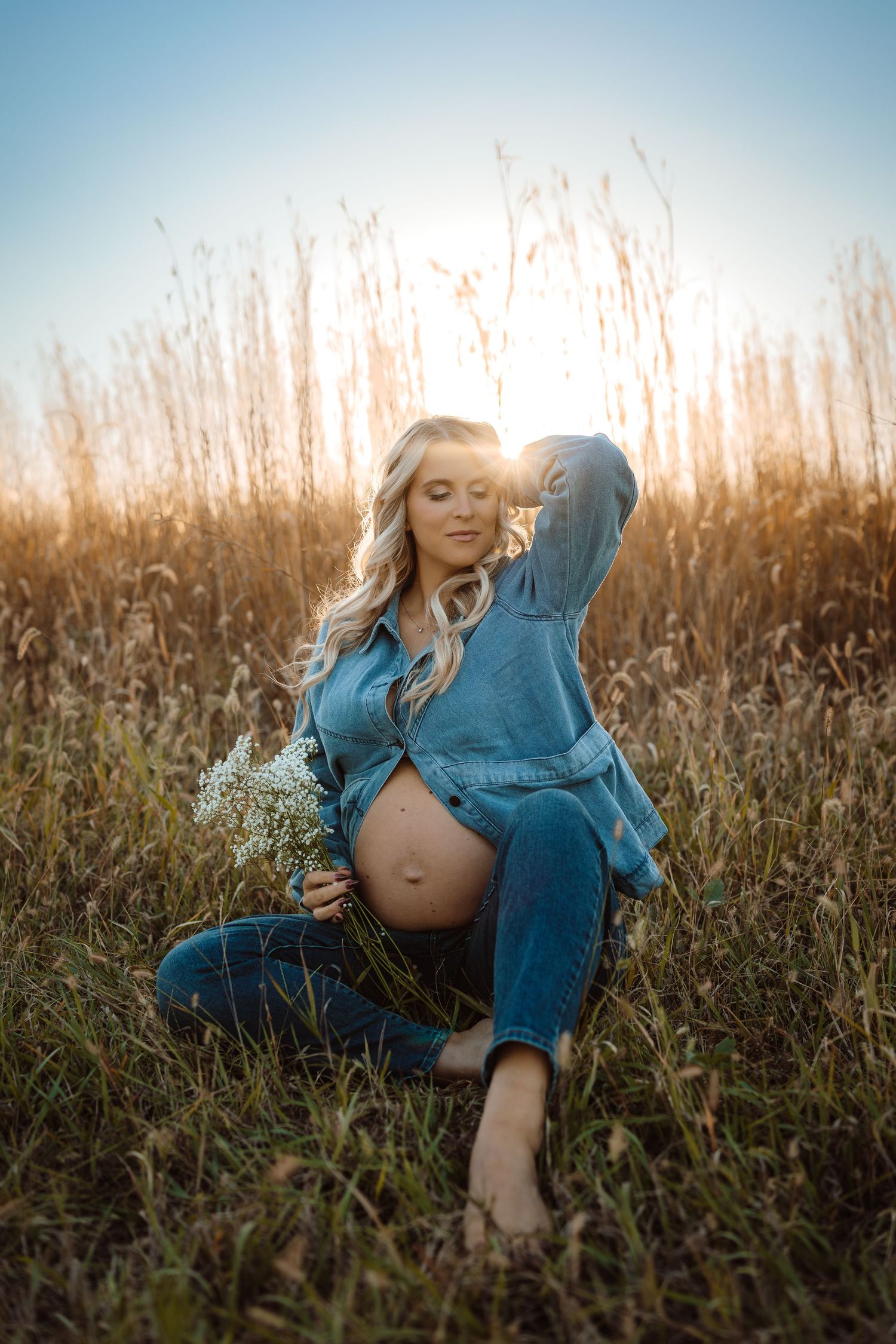 Pregnant woman in a Des Moines area field at sunset during lifestyle maternity photo session.