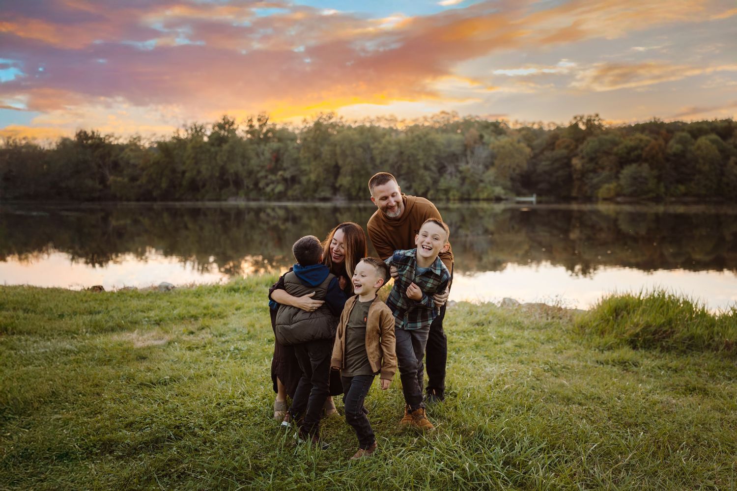 Family plays as in a Des Moines area park at sunset during a lifestyle family photo session.