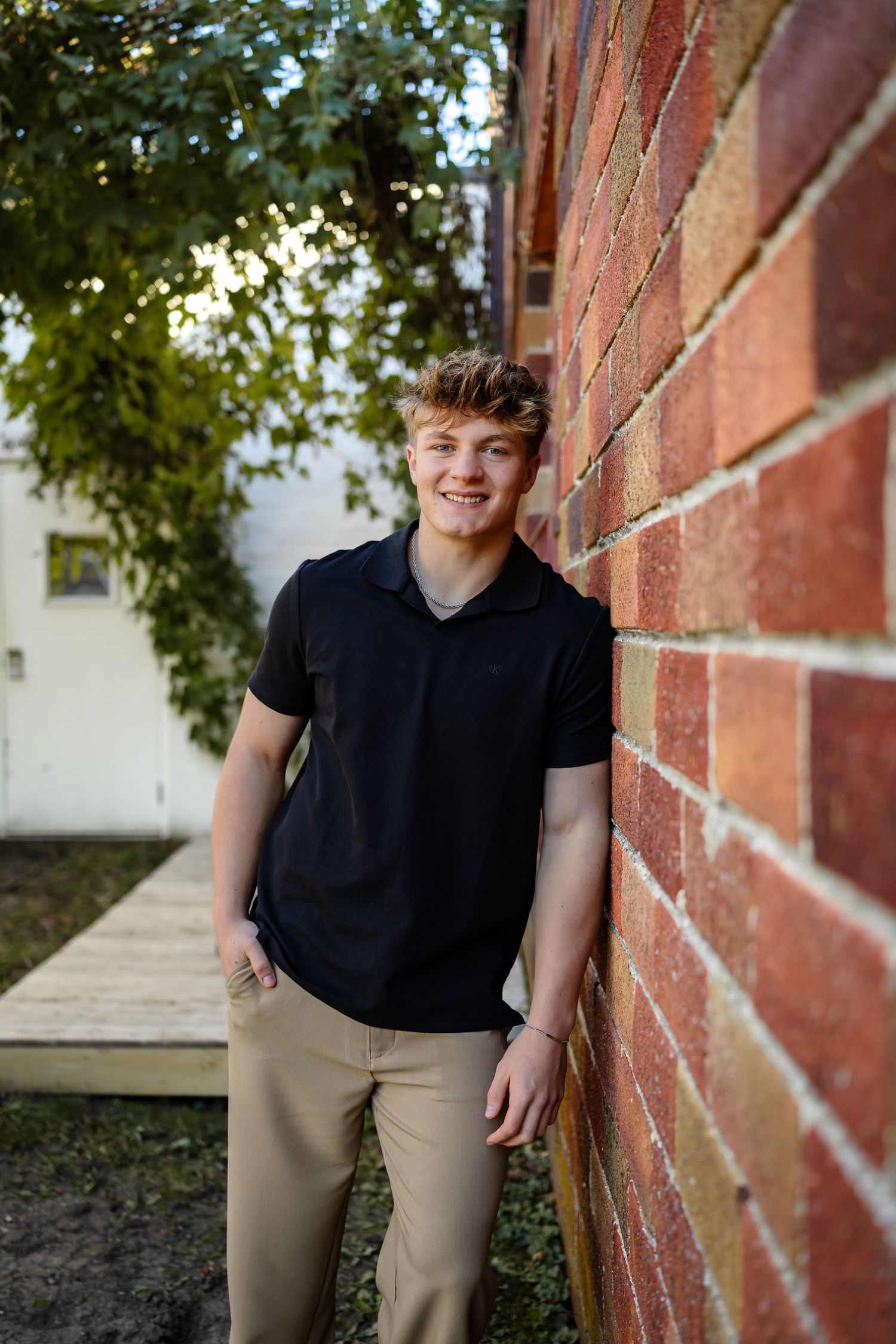 High school senior boy poses in a Des Moines area park during a lifestyle senior photo session.