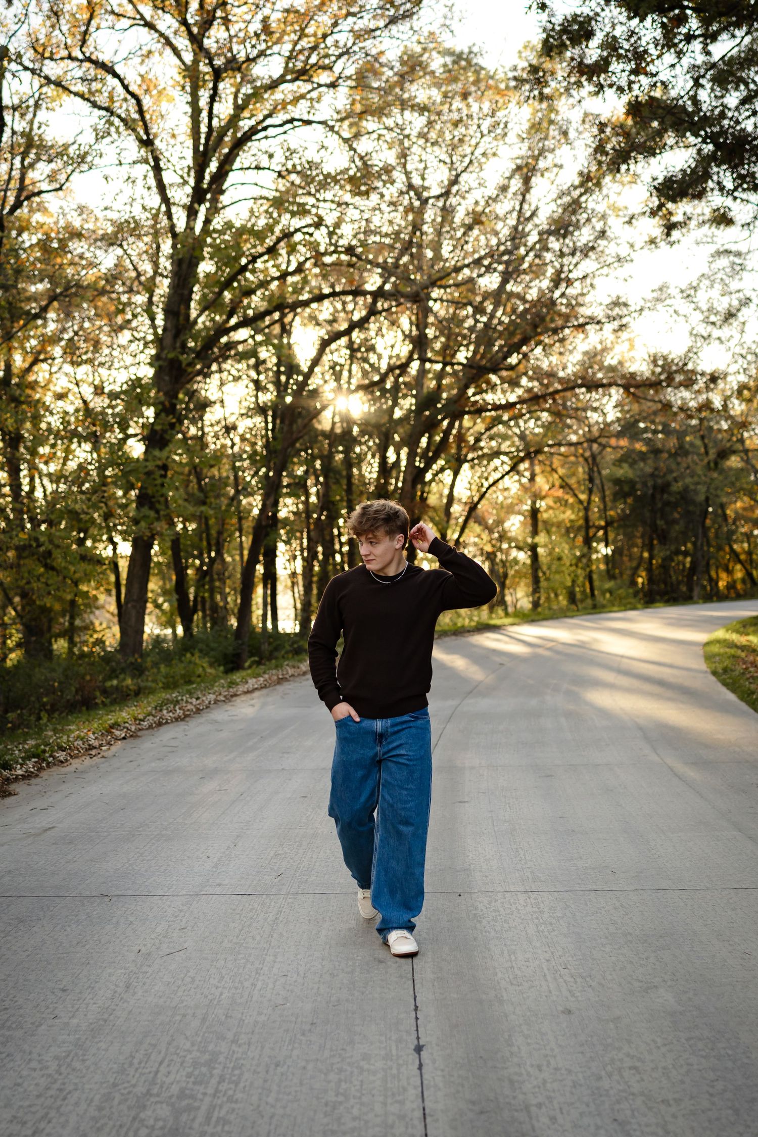 High school senior boy poses in a Des Moines area park during a lifestyle senior photo session.