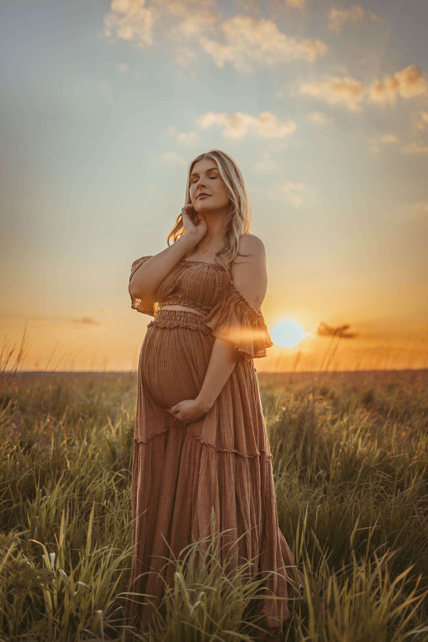 Pregnant woman in a Des Moines area field at sunset during lifestyle maternity photo session.