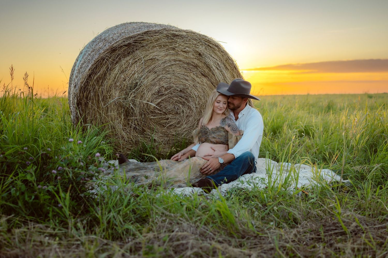 Pregnant woman in a Des Moines area field at sunset during lifestyle maternity photo session.