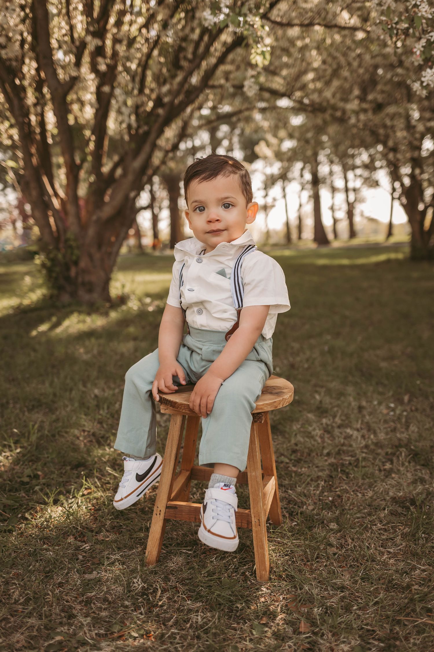 Little boy sits on stool in a Des Moines area park at sunset during a lifestyle family child milestone photo session.