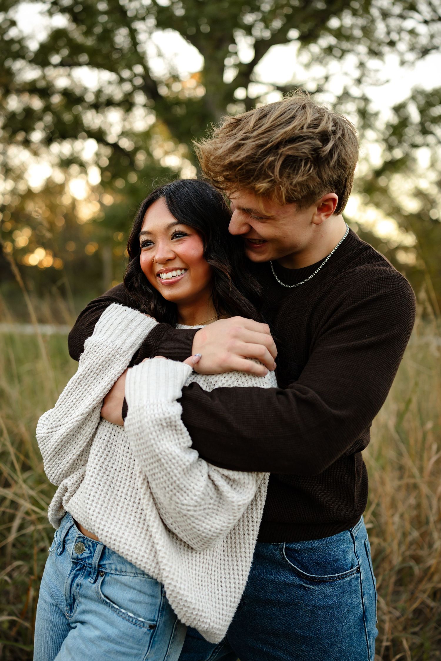 Couple hugs in a Des Moines area park at sunset during a lifestyle family photo session.